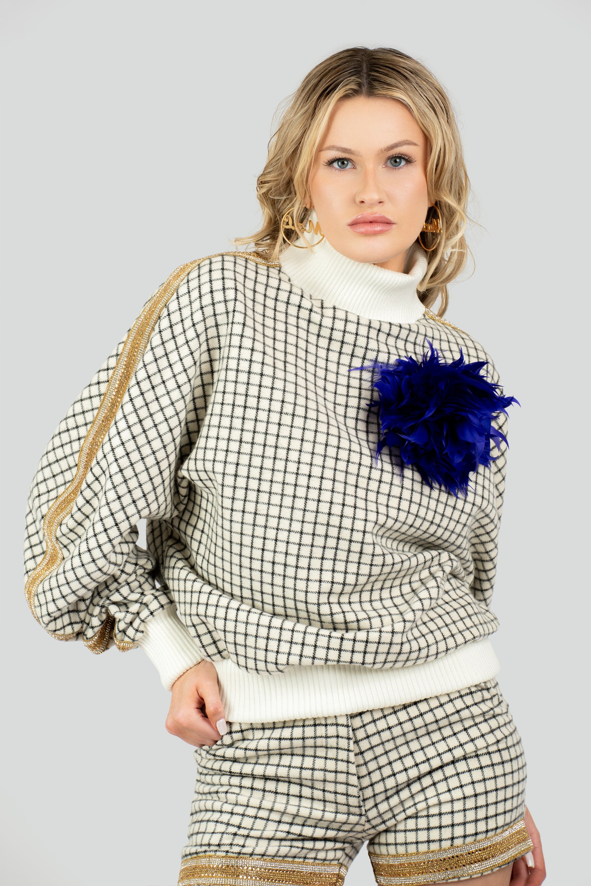  Close-up texture shot of a mid-weight cotton-blend jacquard knit sweater highlighting fine ribbed stitching on the collar, cuffs, and hem