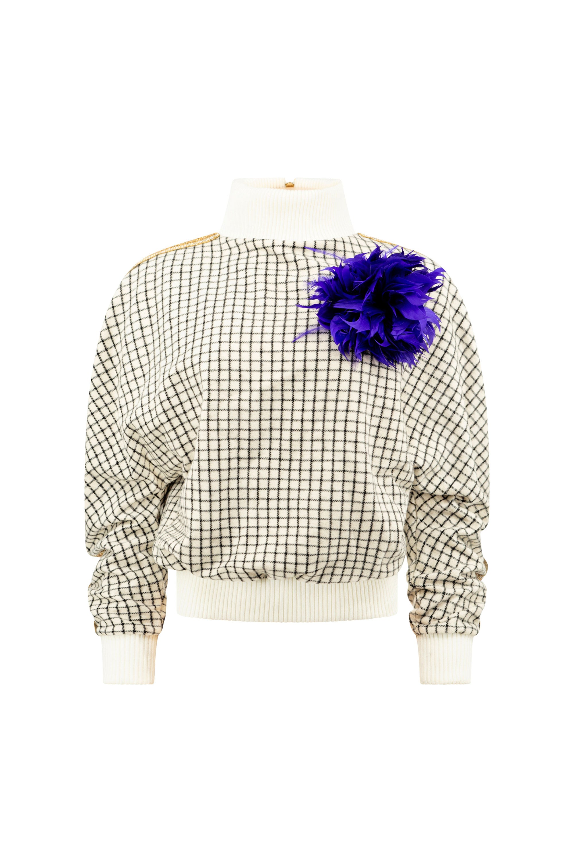 A cream colored grid patterned sweater with gold detail and an indigo feathered brooch on a white background