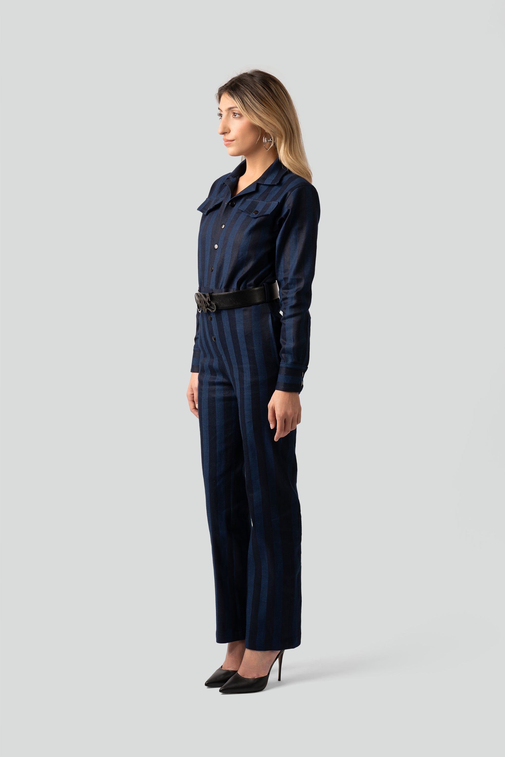  Side view of a long-sleeve striped utility jumpsuit showcasing structured shoulders, a classic collar, and an ingrained stretch waistband for a contoured fit