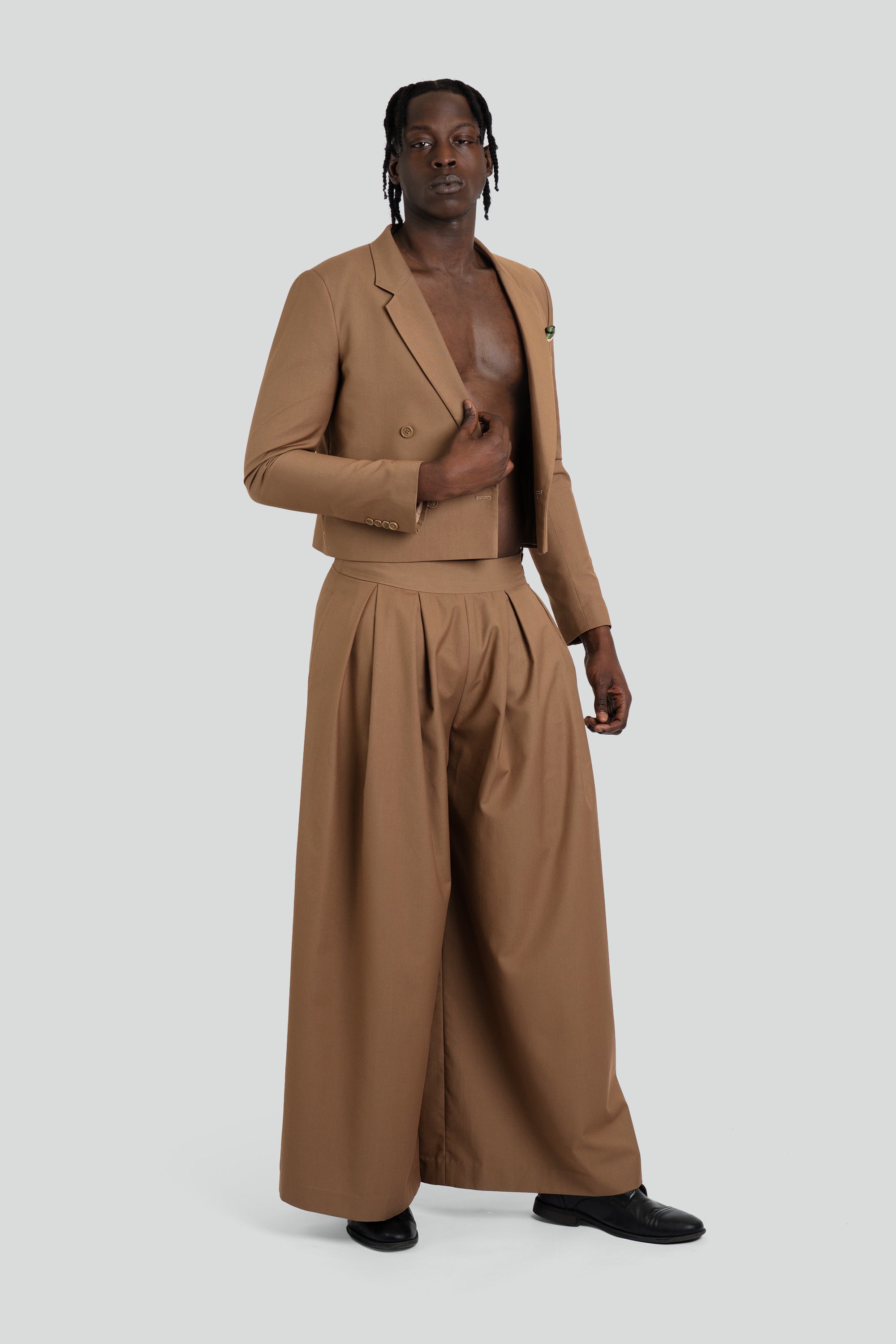 Person wearing a brown suit on a white background
