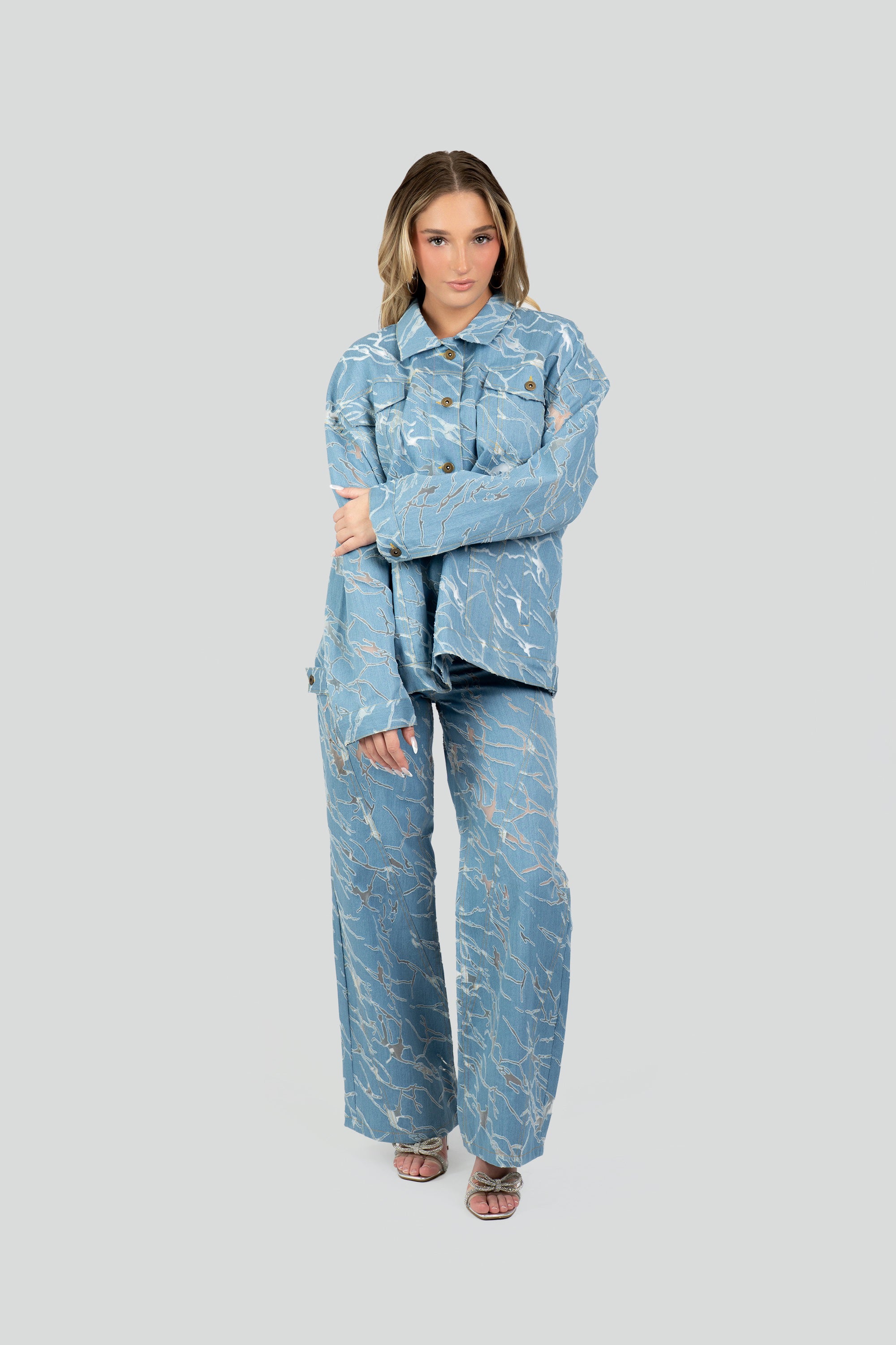 Woman wearing a blue patterned denim outfit on a white background