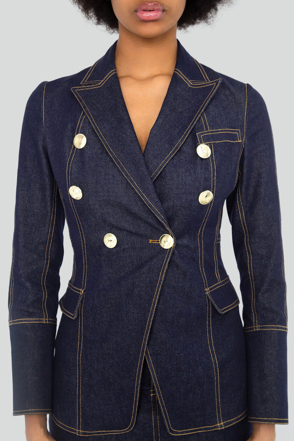 Close up view of a dark indigo denim corset blazer jacket featuring bright contrast topstitching and structured tailored seams