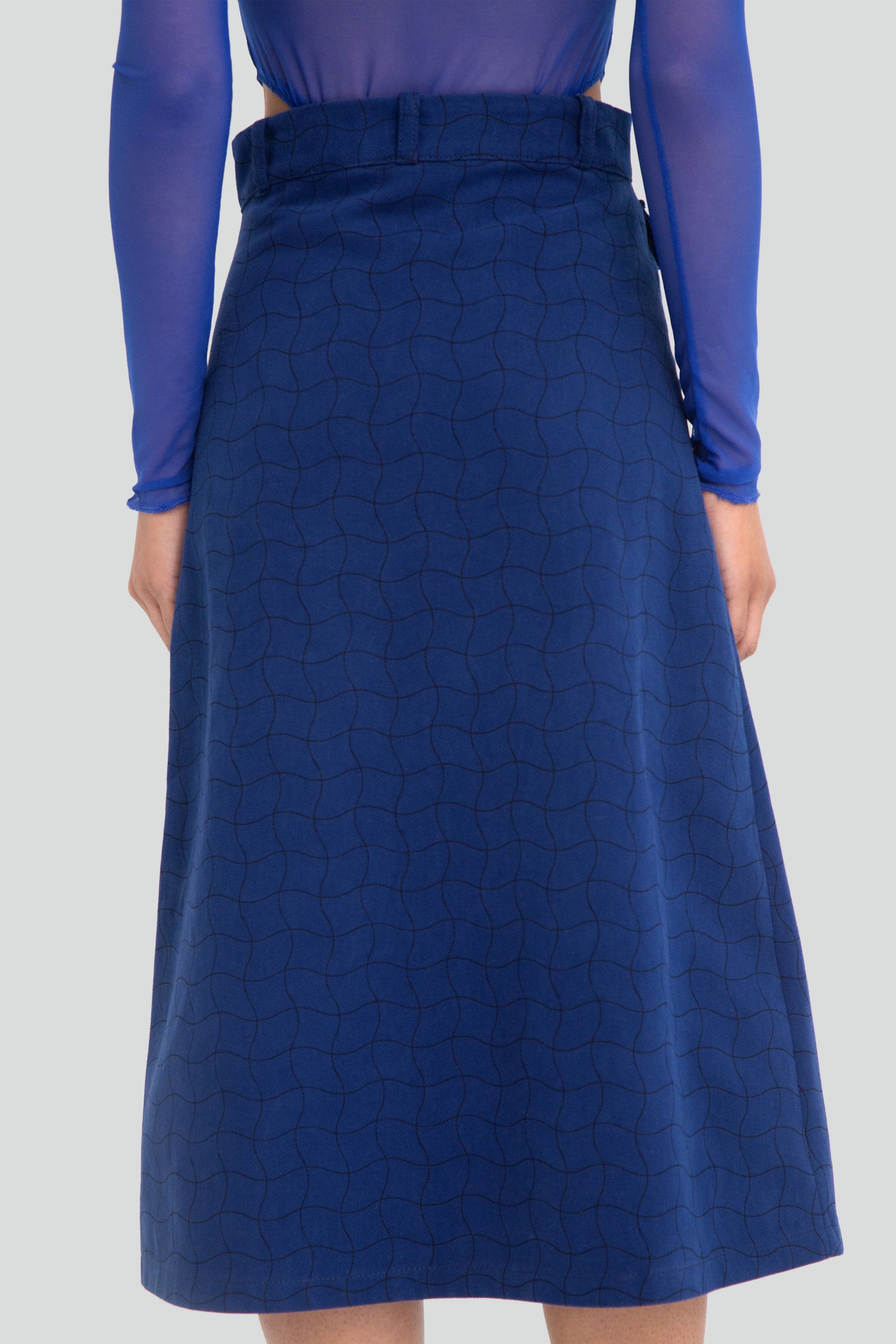 Blue patterned skirt worn by a person against a plain background