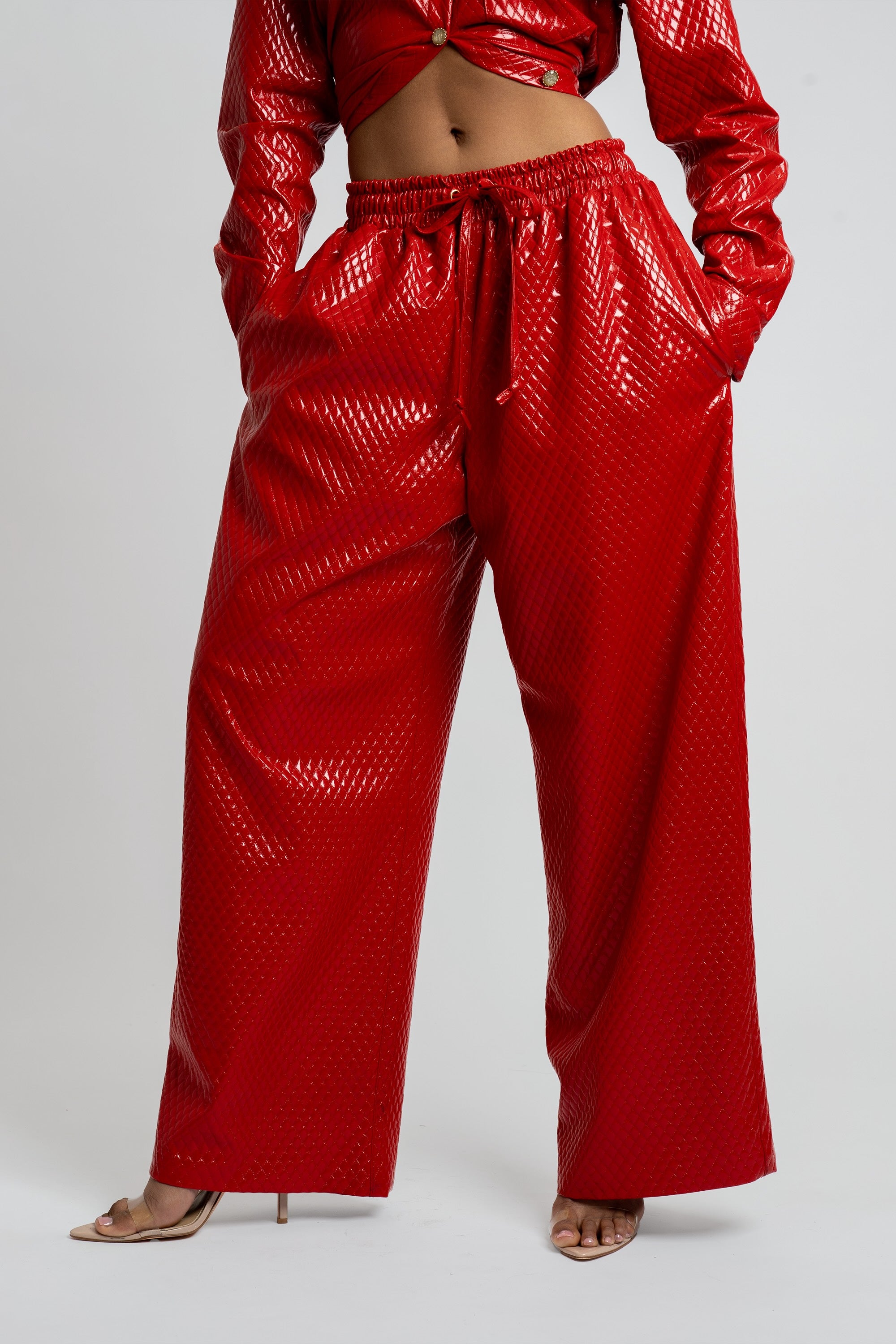 Red textured outfit with wide-leg pants and cropped jacket on a white background