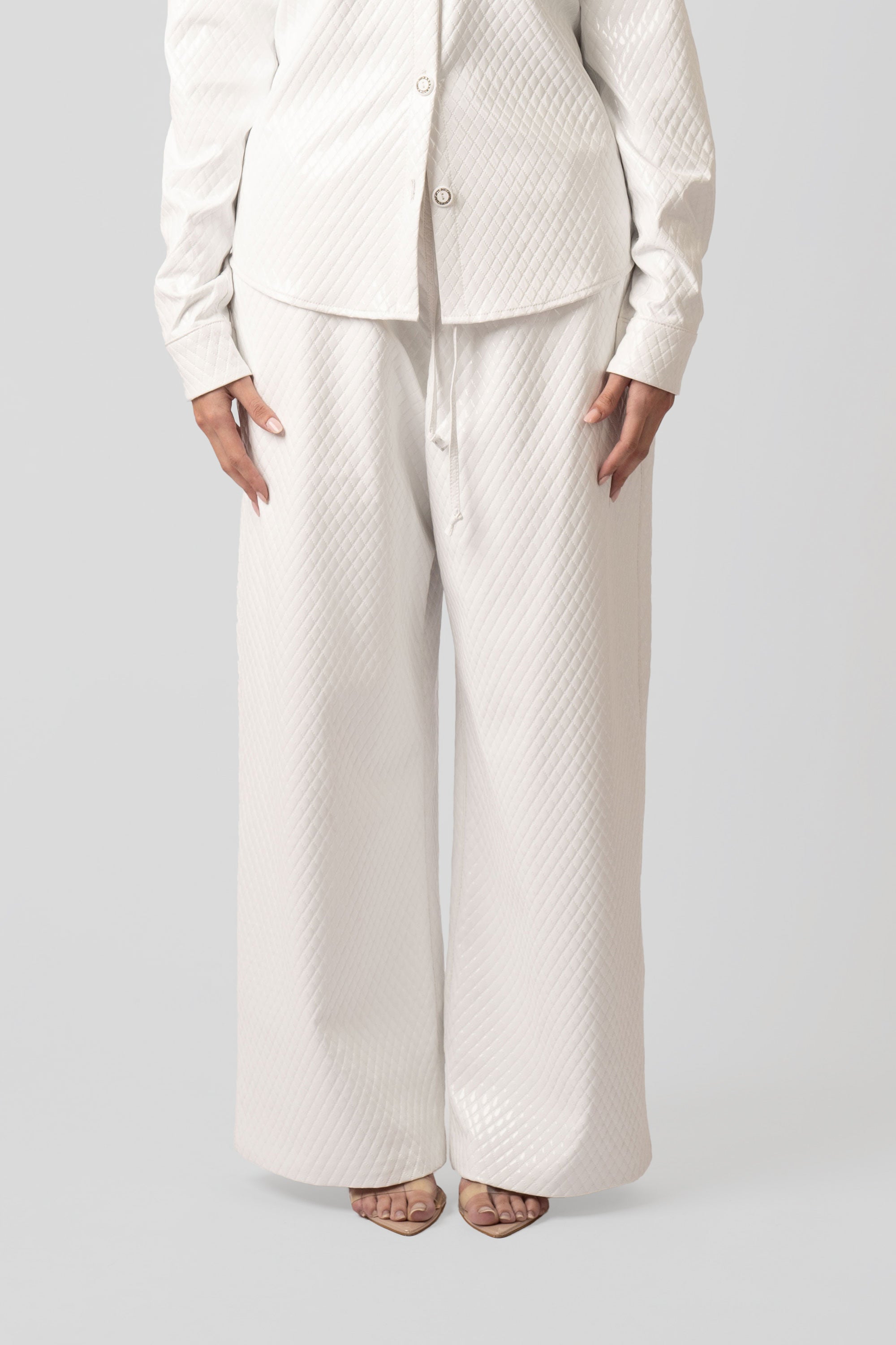 Person wearing a white textured outfit on a plain background