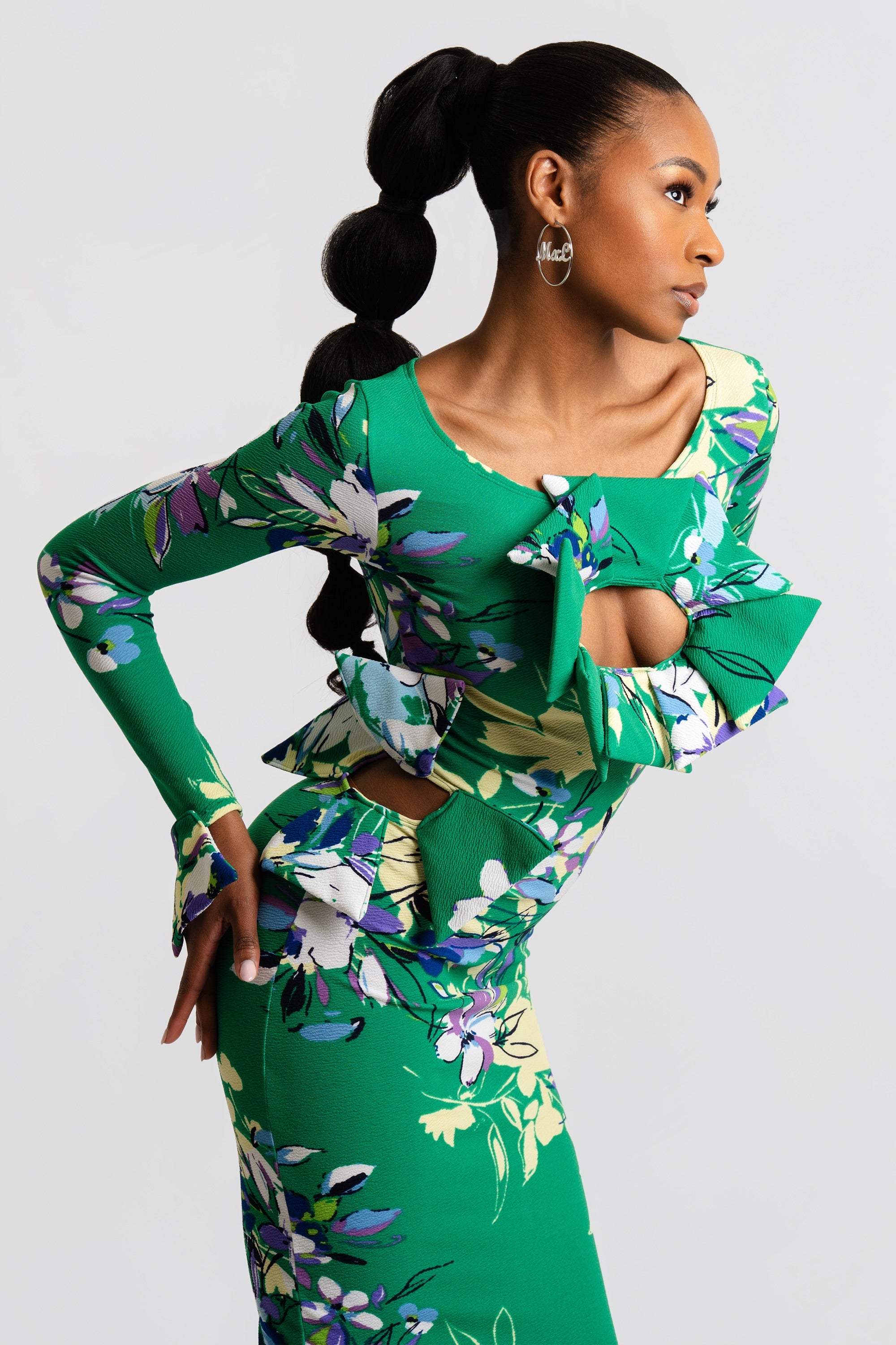 Woman wearing a green floral dress against a white background