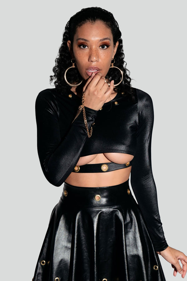 Model styling a luxury black slashed cutout blouse with a high waisted leather midi skirt for a glamorous night out outfit