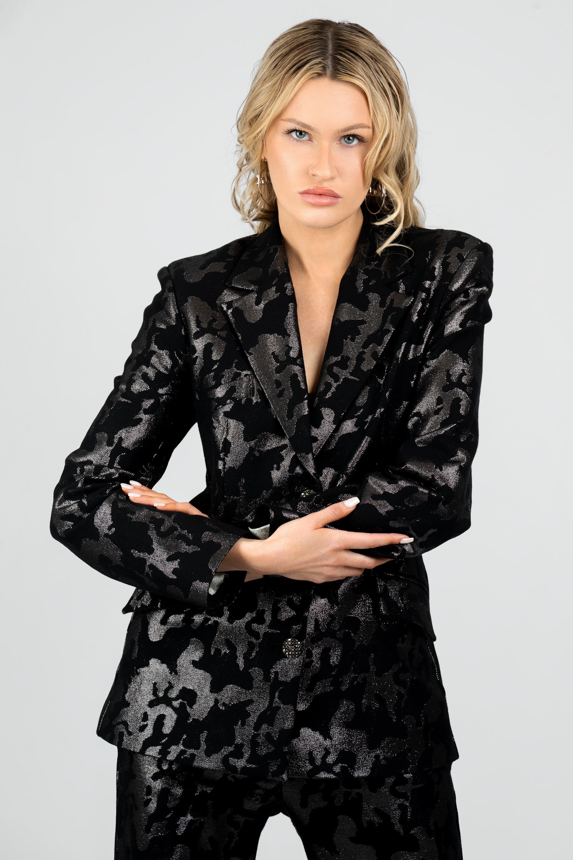Close up of a woman wearing a black camo suit set on a white background