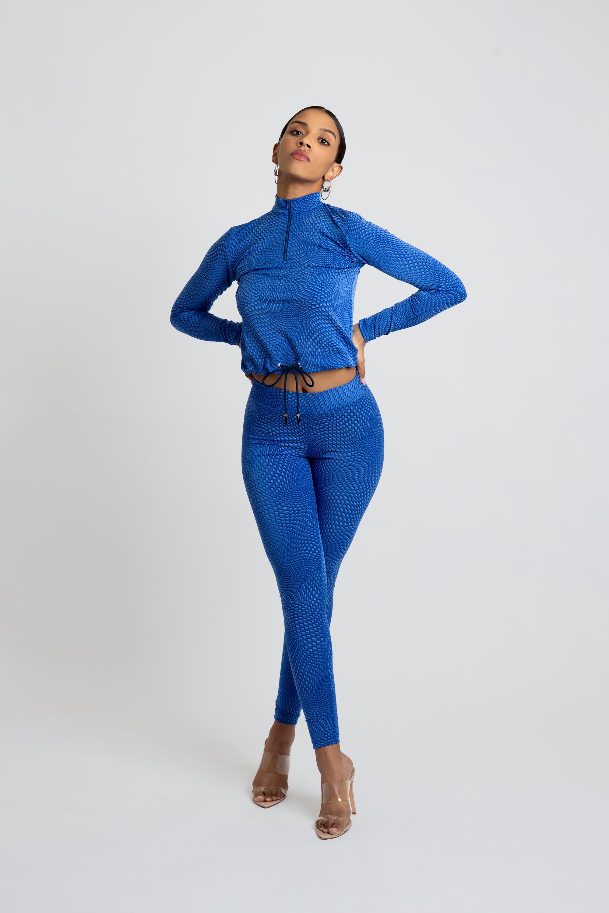 Model wearing a blue patterned workout set on a white background