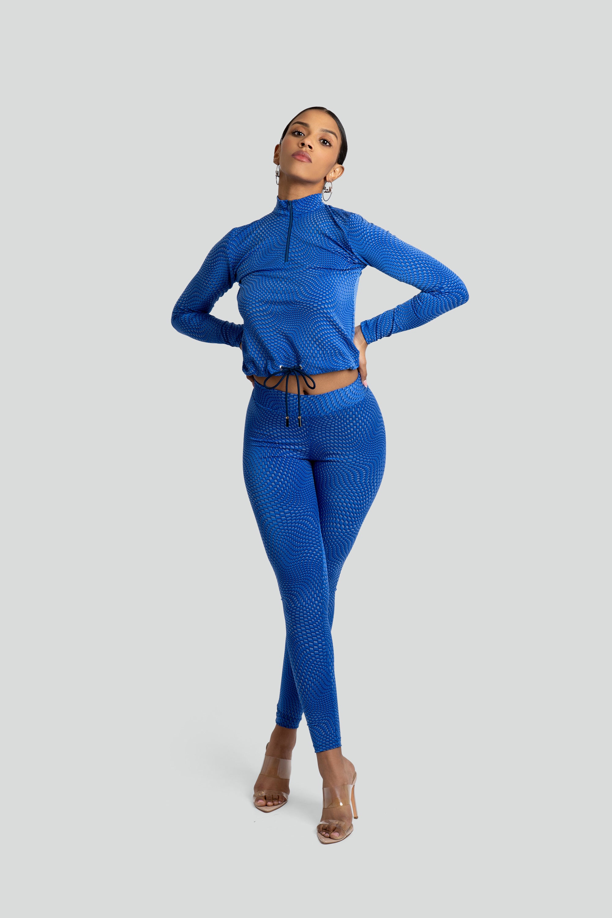 Model wearing a blue patterned workout set on a white background