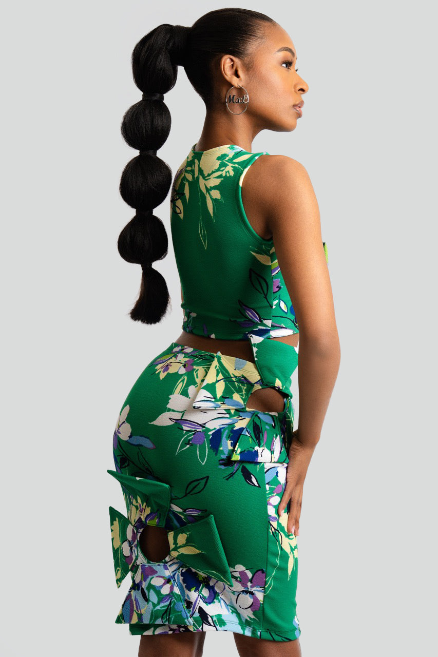 Woman wearing a green floral dress against a gray background