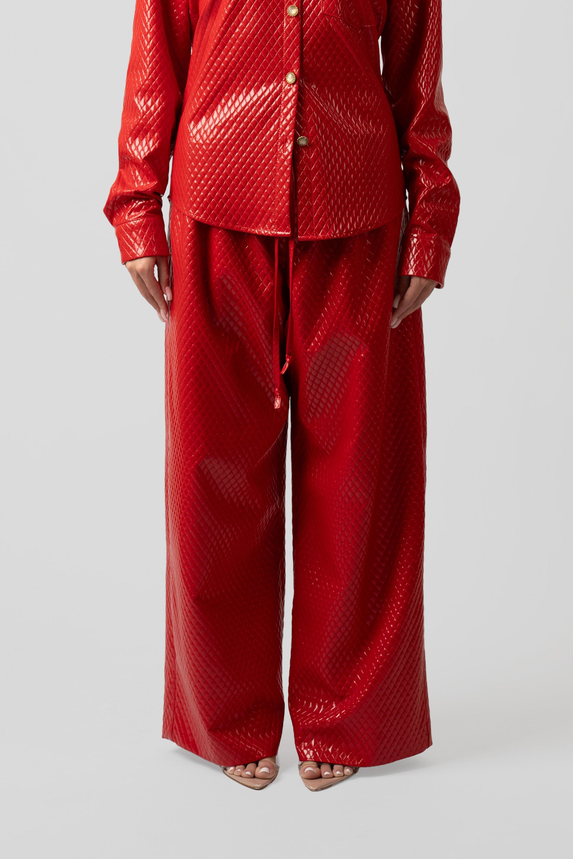 Red quilted outfit with matching pants on a white background