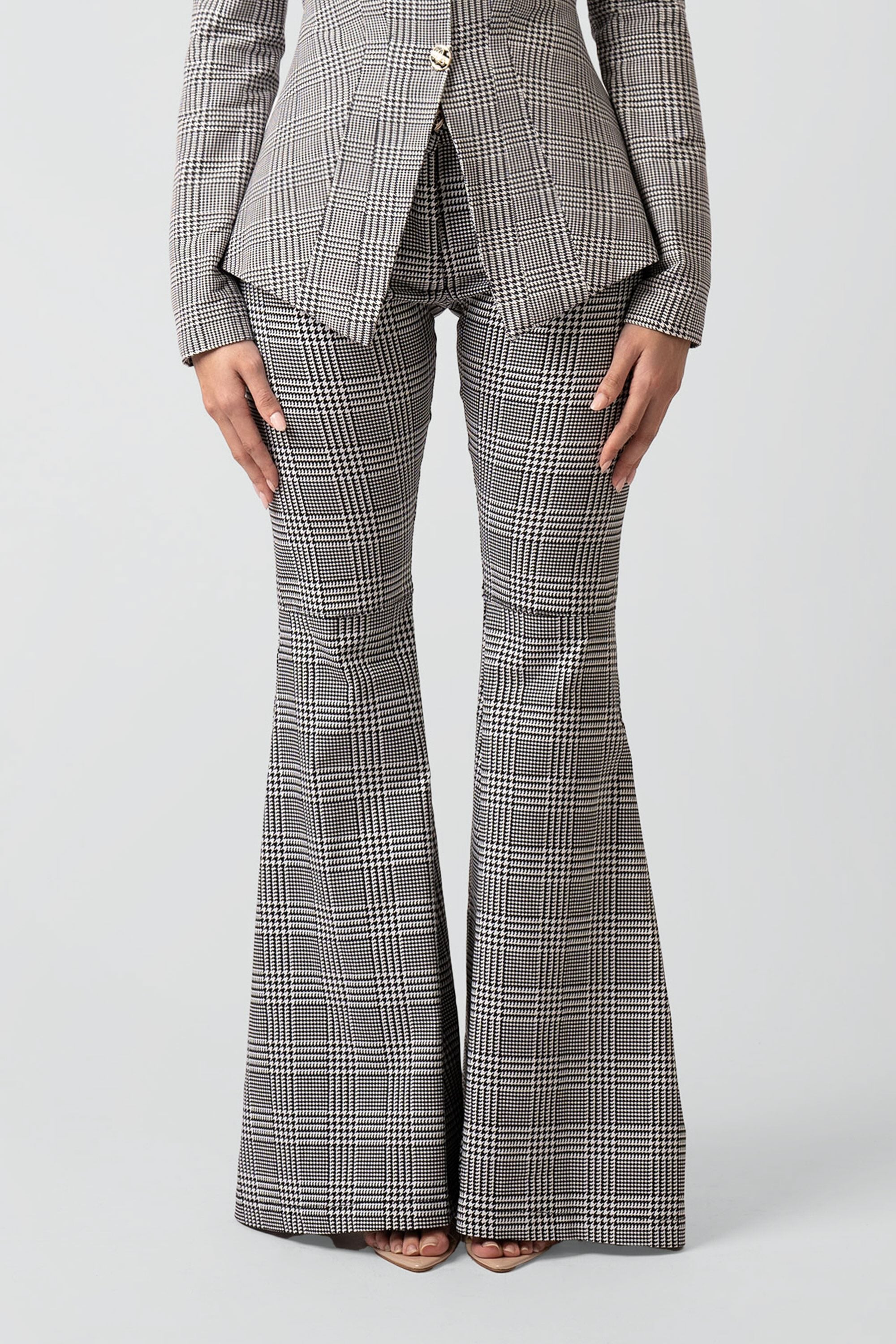 Close up of grey plaid pants with a flared bottom on a white background