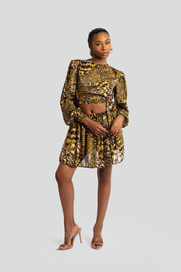 Two-piece women's dress set in a bold abstract animal print featuring a long-sleeve crop top with voluminous shoulders and a matching high-waisted pleated maxi skirt