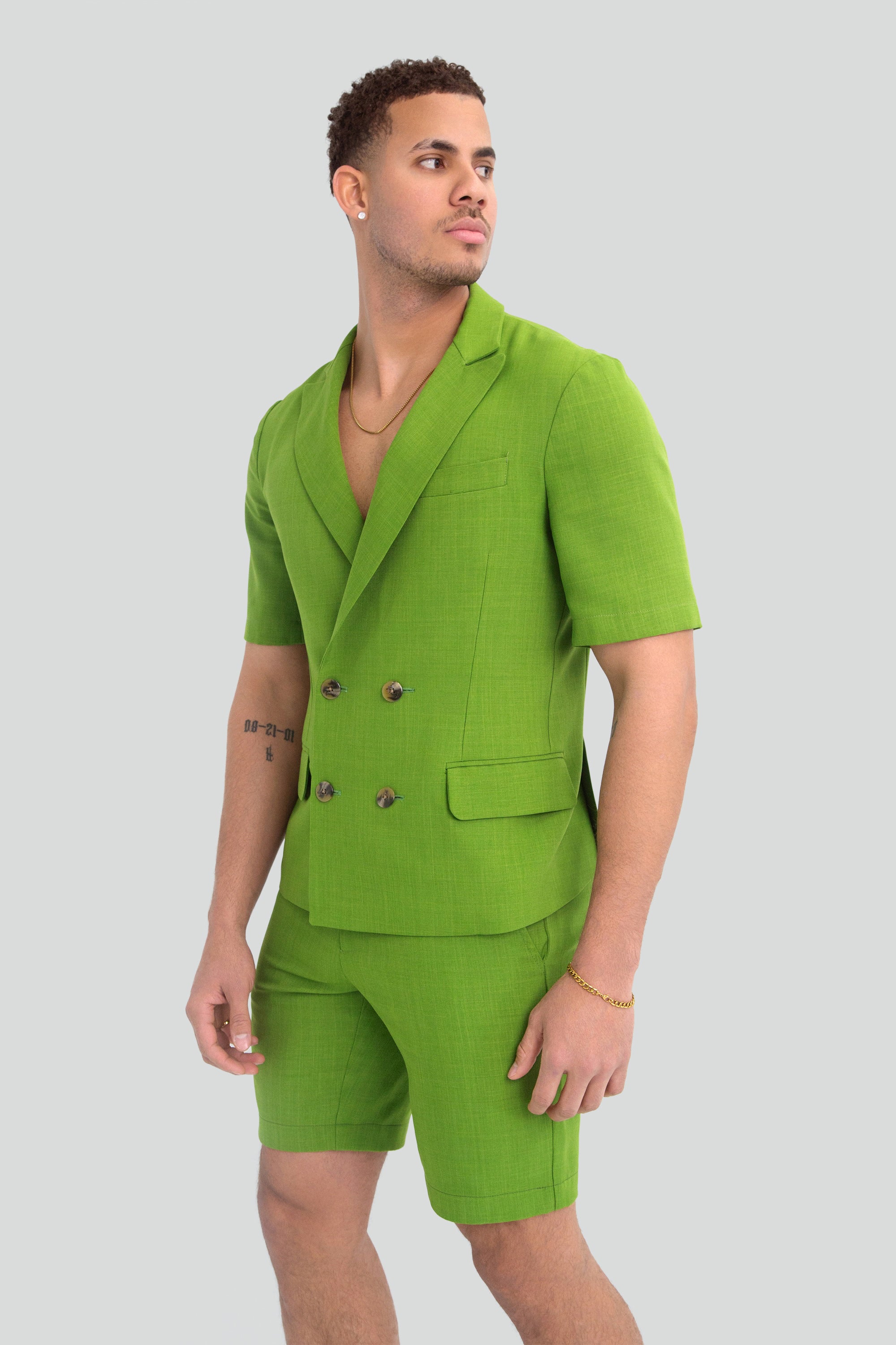 Man wearing a green short suit on a plain background