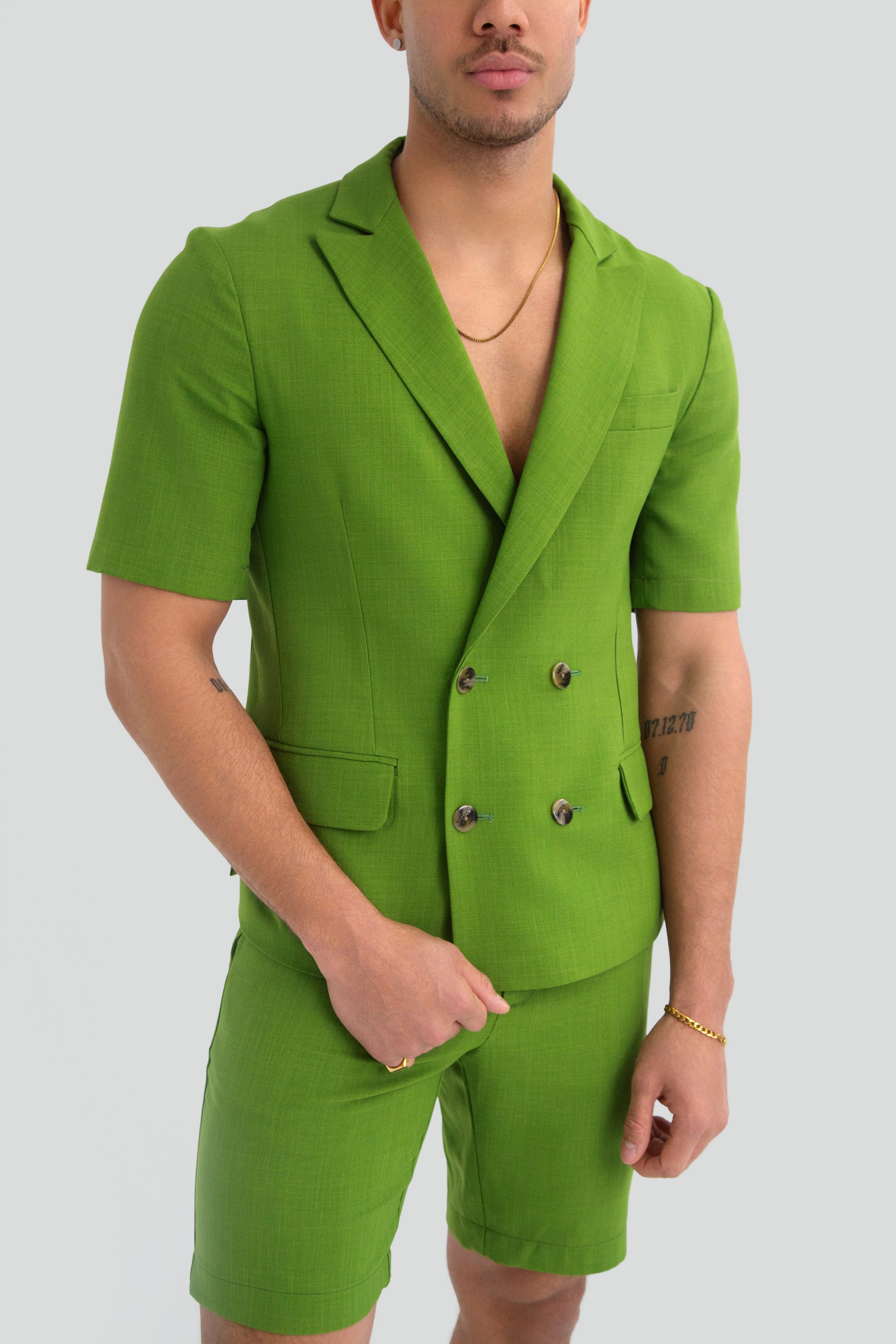 Man wearing a green short suit on a plain background