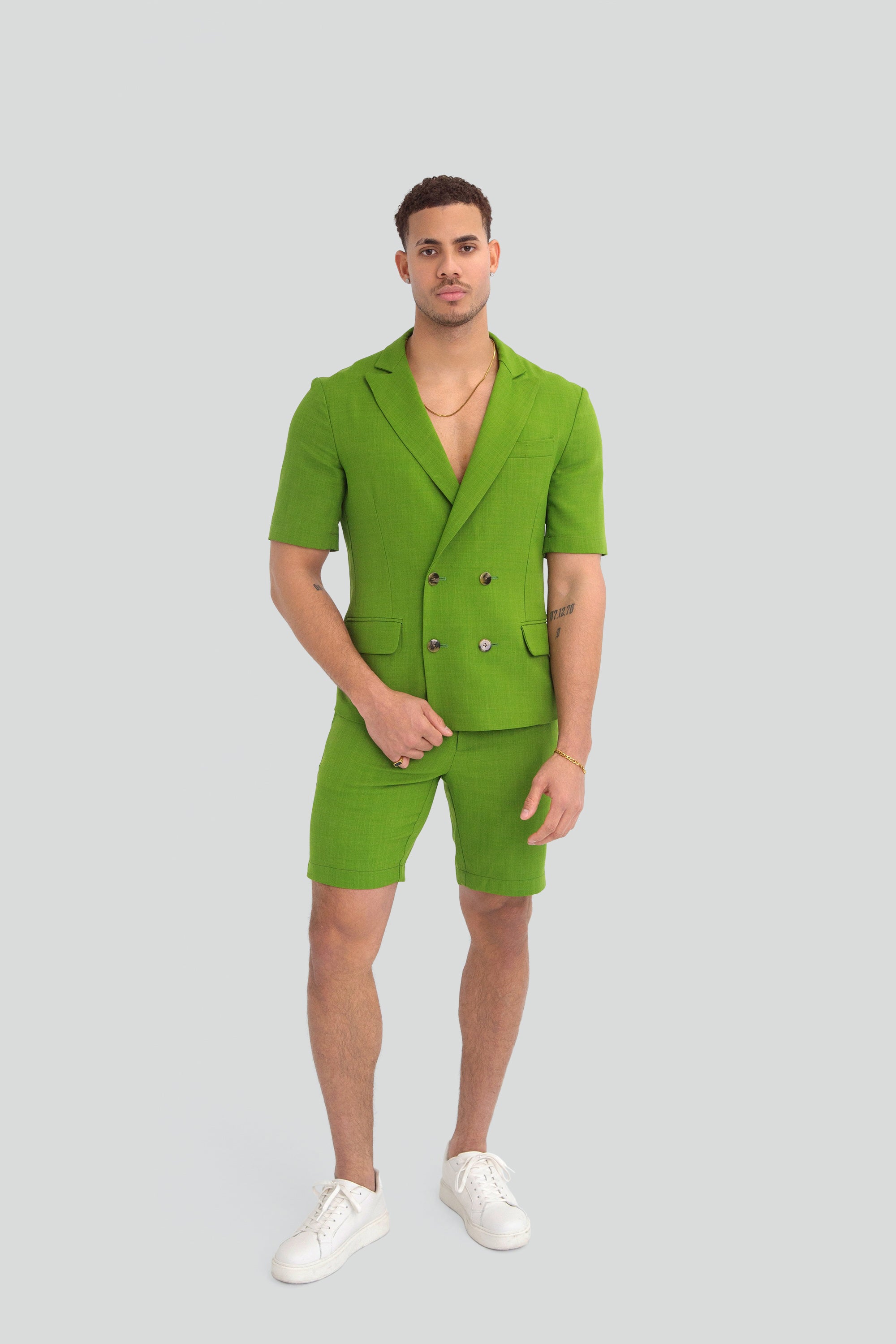 Man wearing a green short suit on a plain background