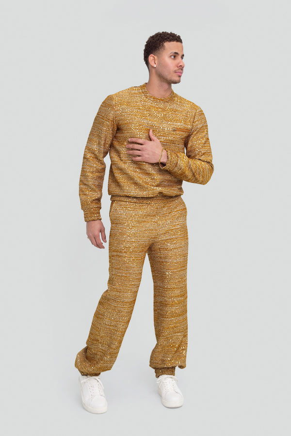 Model styling a luxury mens gold star co ord suit in a shiny metallic tweed knitwear fabric with shimmering gold sequins