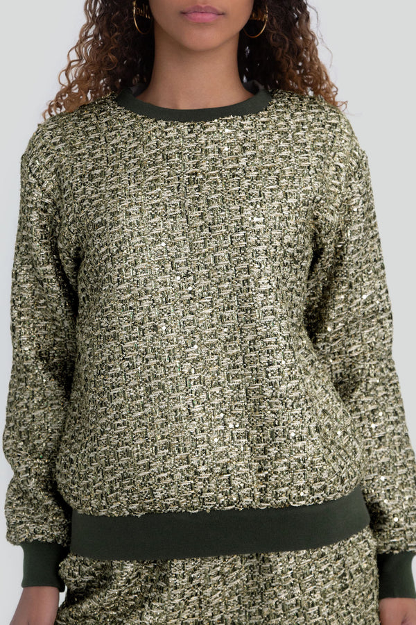 Woman wearing a greenish gold metallic tweed sweater featuring a relaxed fit knitwear silhouette with a classic ribbed neckline