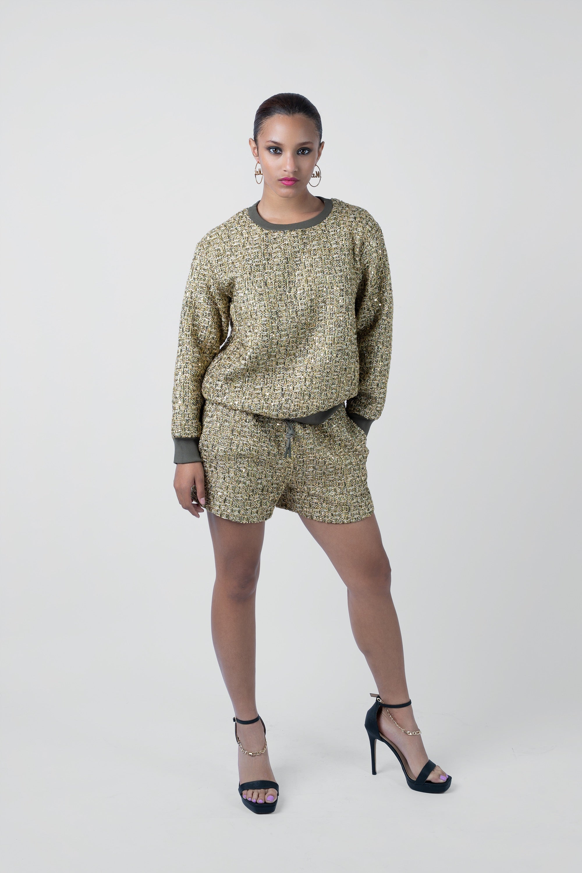 Person wearing a textured sweater and shorts set against a white background