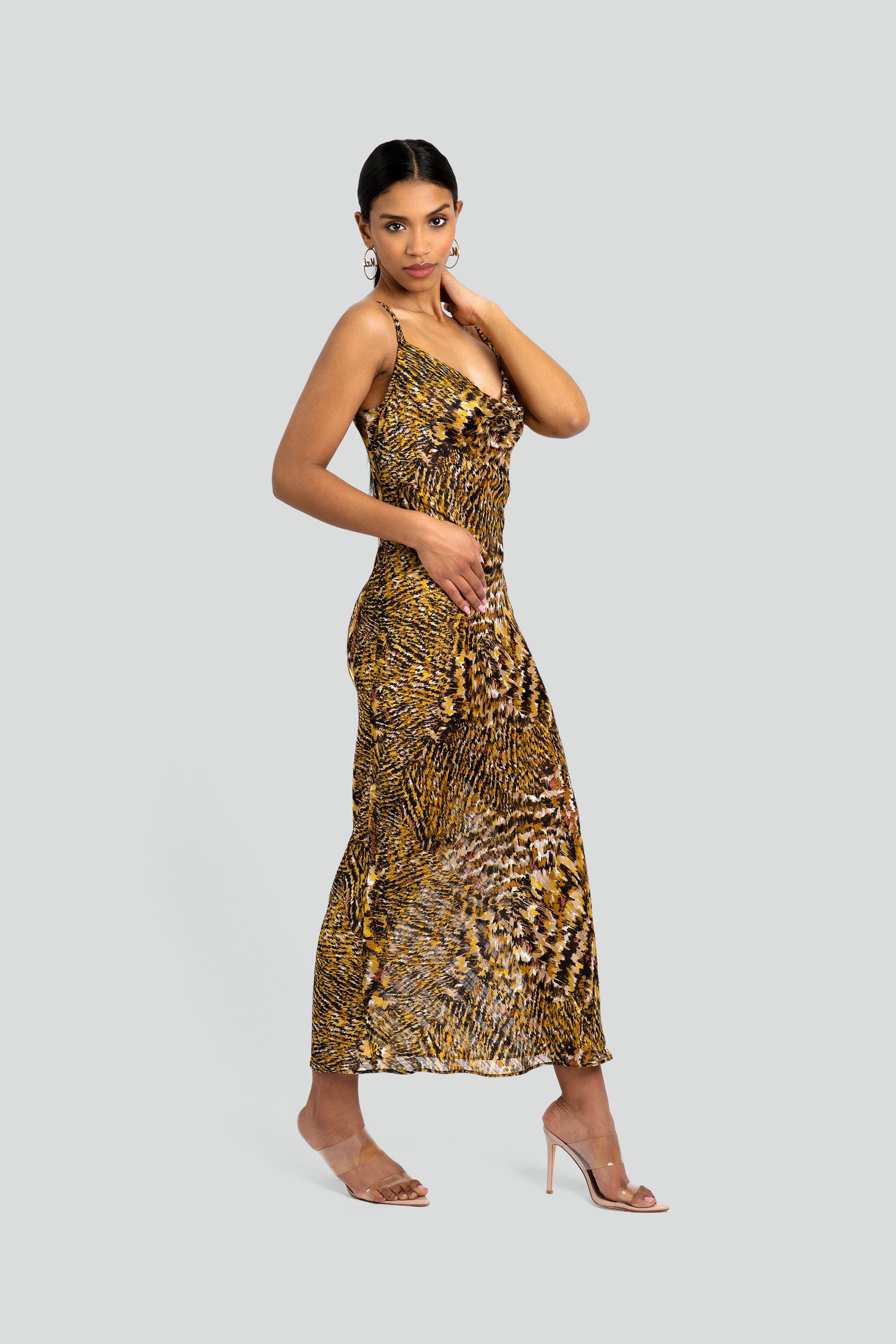 Woman wearing an abstract leopard print dress on a white background