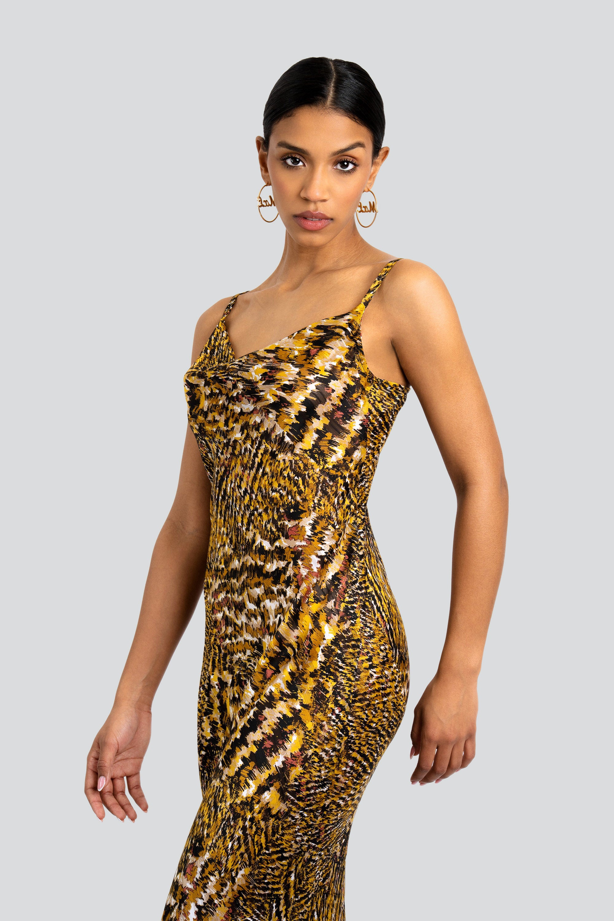 Woman wearing an abstract leopard print dress on a white background