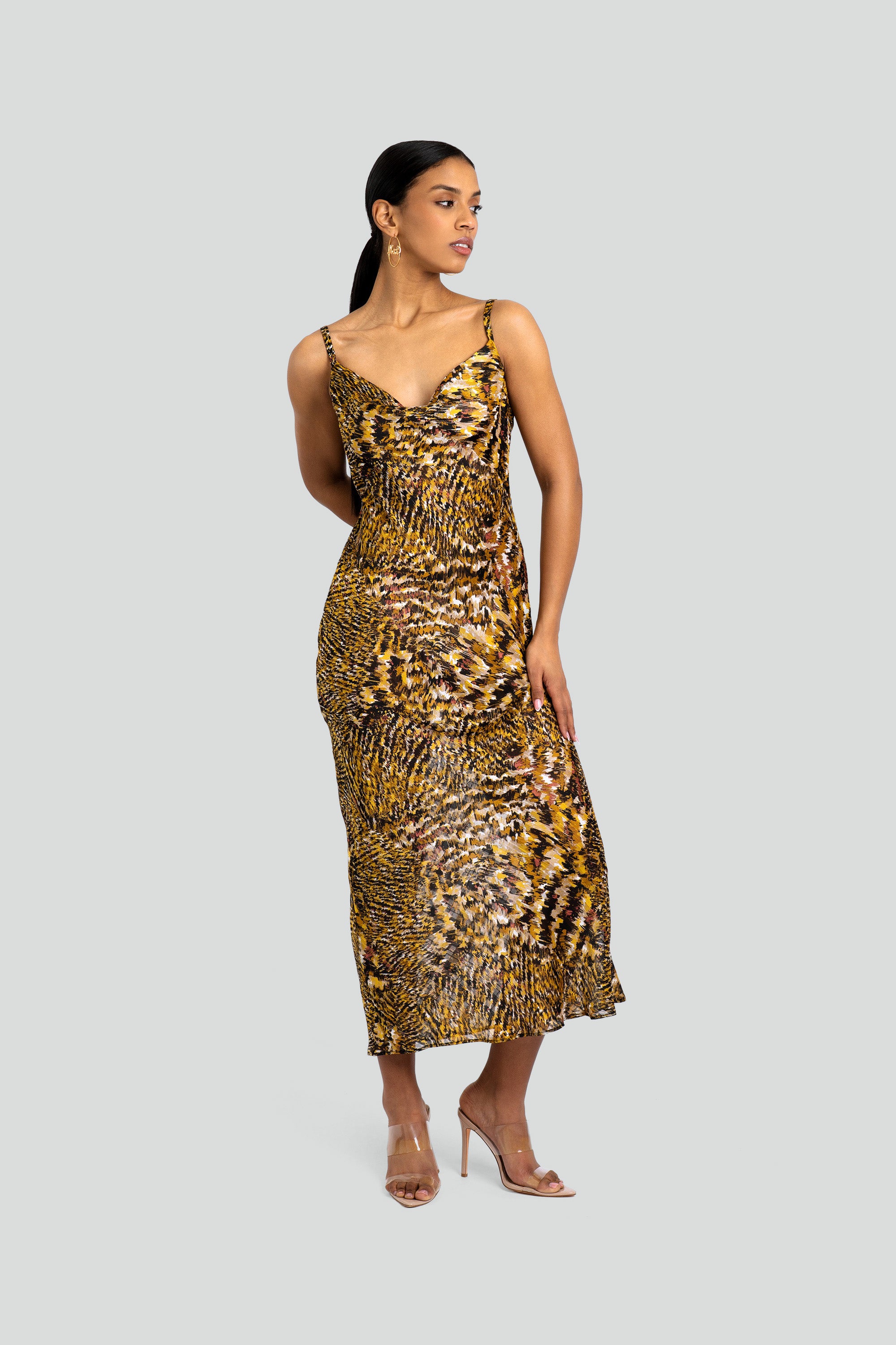 Woman wearing an abstract leopard print dress on a white background