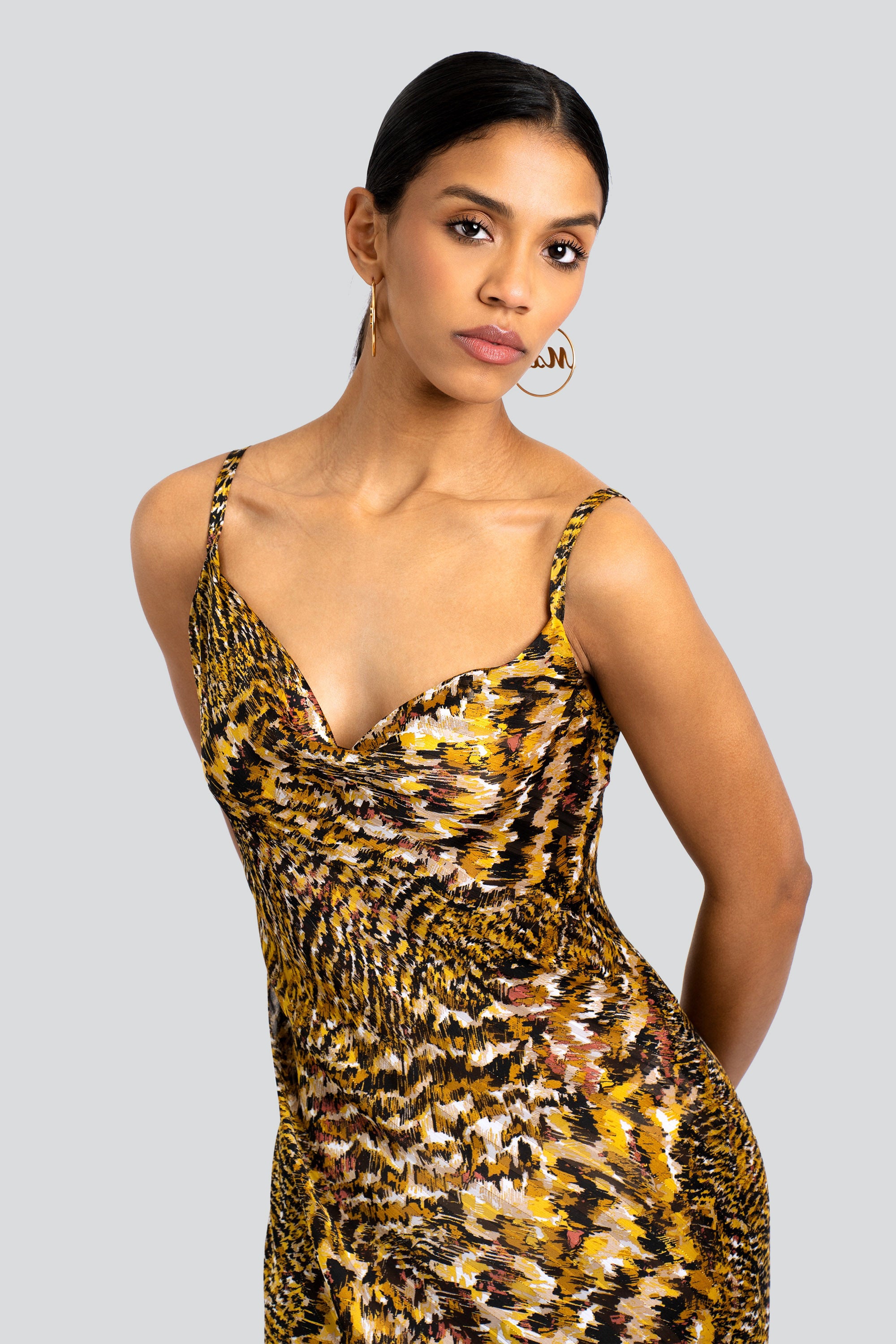 Woman wearing an abstract leopard print dress on a white background