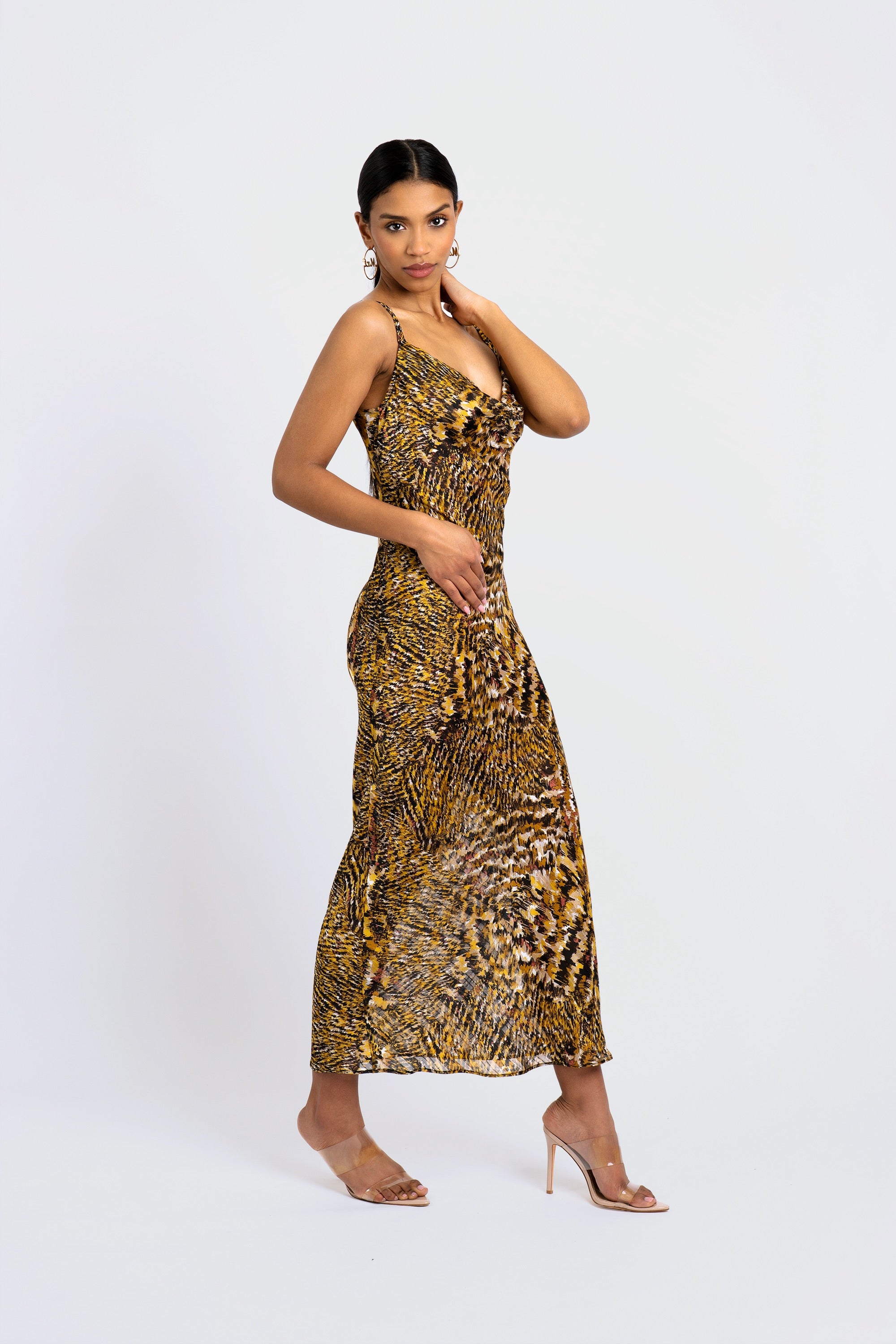 Woman wearing an abstract leopard print dress on a white background