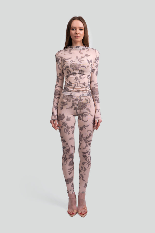 Model styling a luxury cream and gray muted floral two piece set with a translucent second skin silhouette