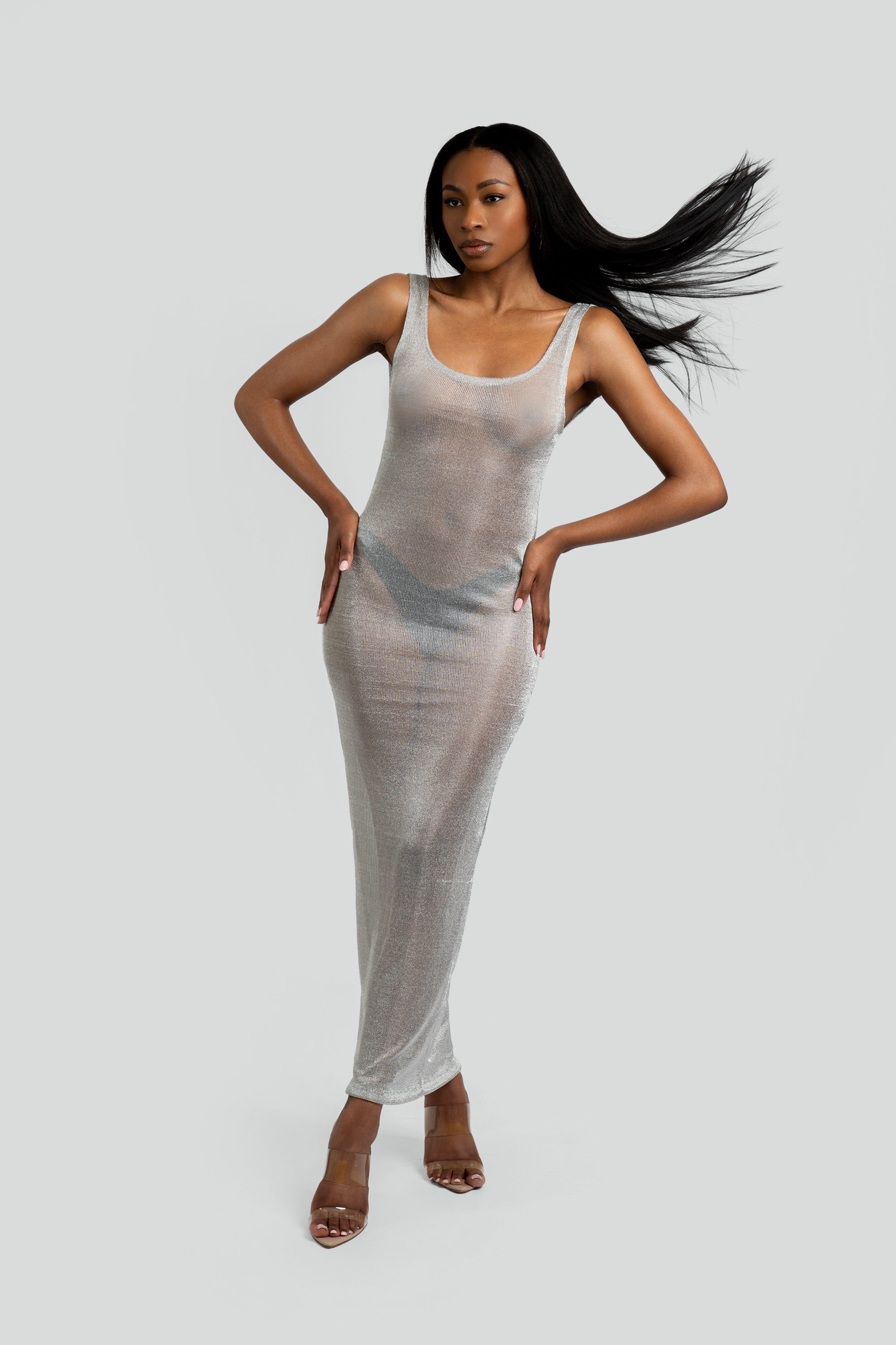 Woman wearing a silver metallic dress against a white background