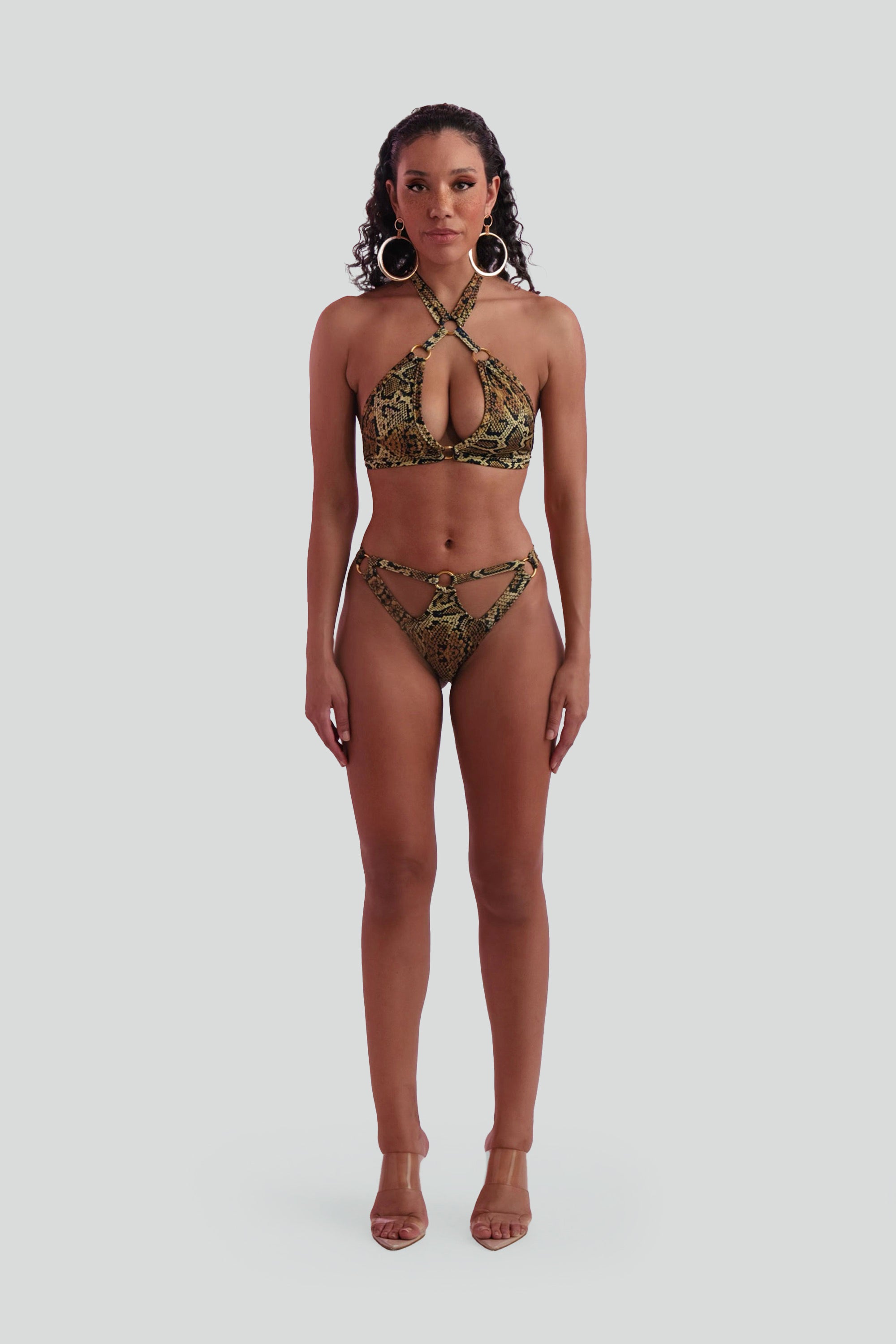 Woman wearing a snake print bikini on a gray background