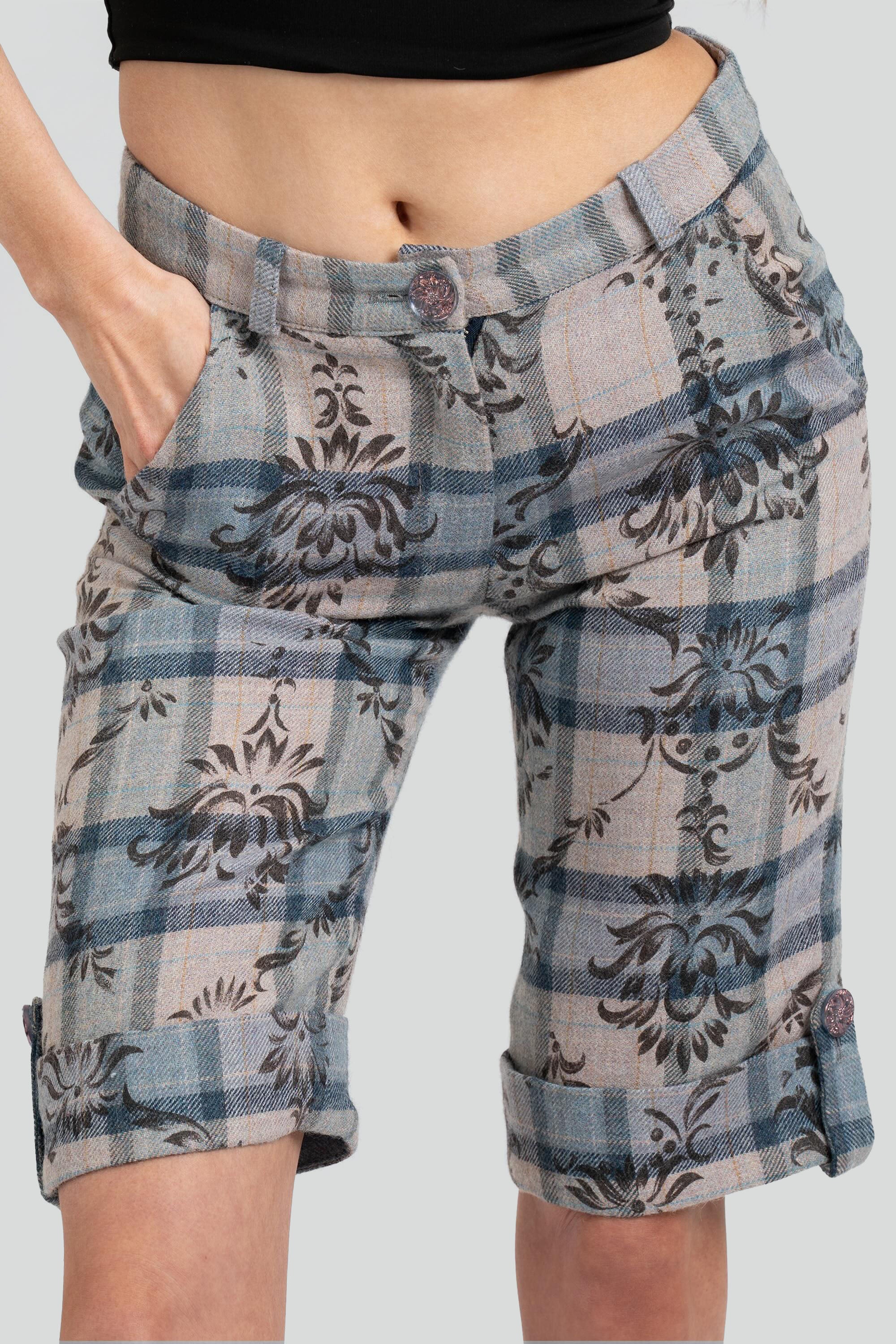 Close up of a woman wearing floral and plaid patterned shorts on a white background