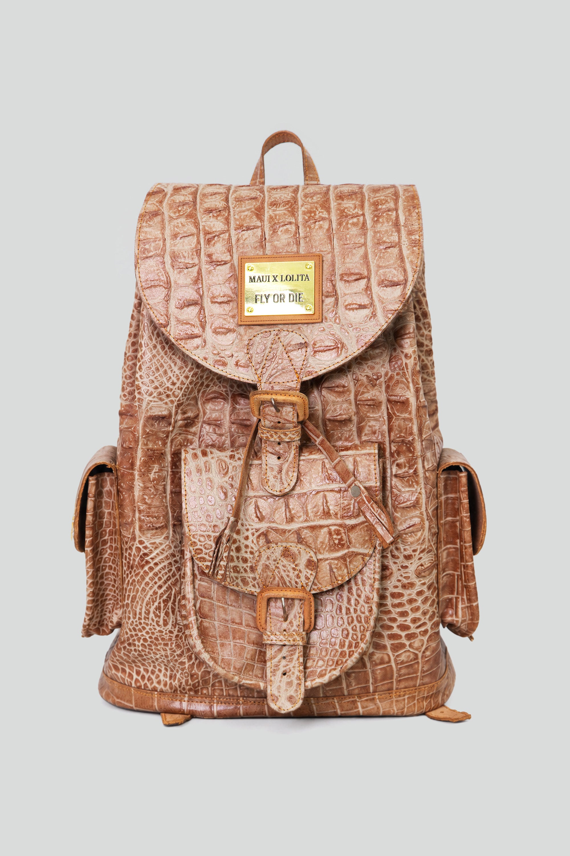 Brown crocodile-patterned leather backpack with a buckle enclosure on a light gray background