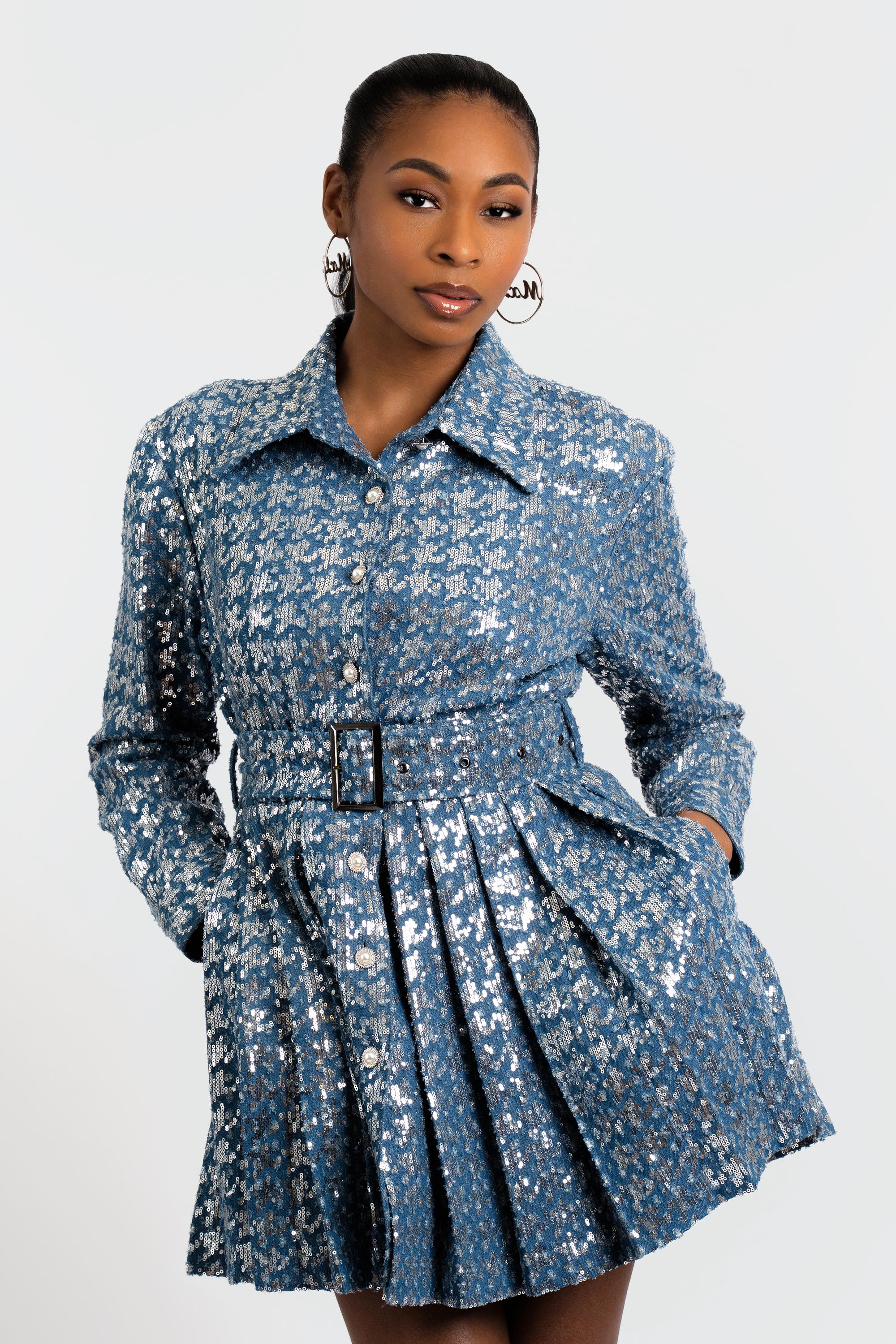 Woman wearing a blue sequin dress against a white background