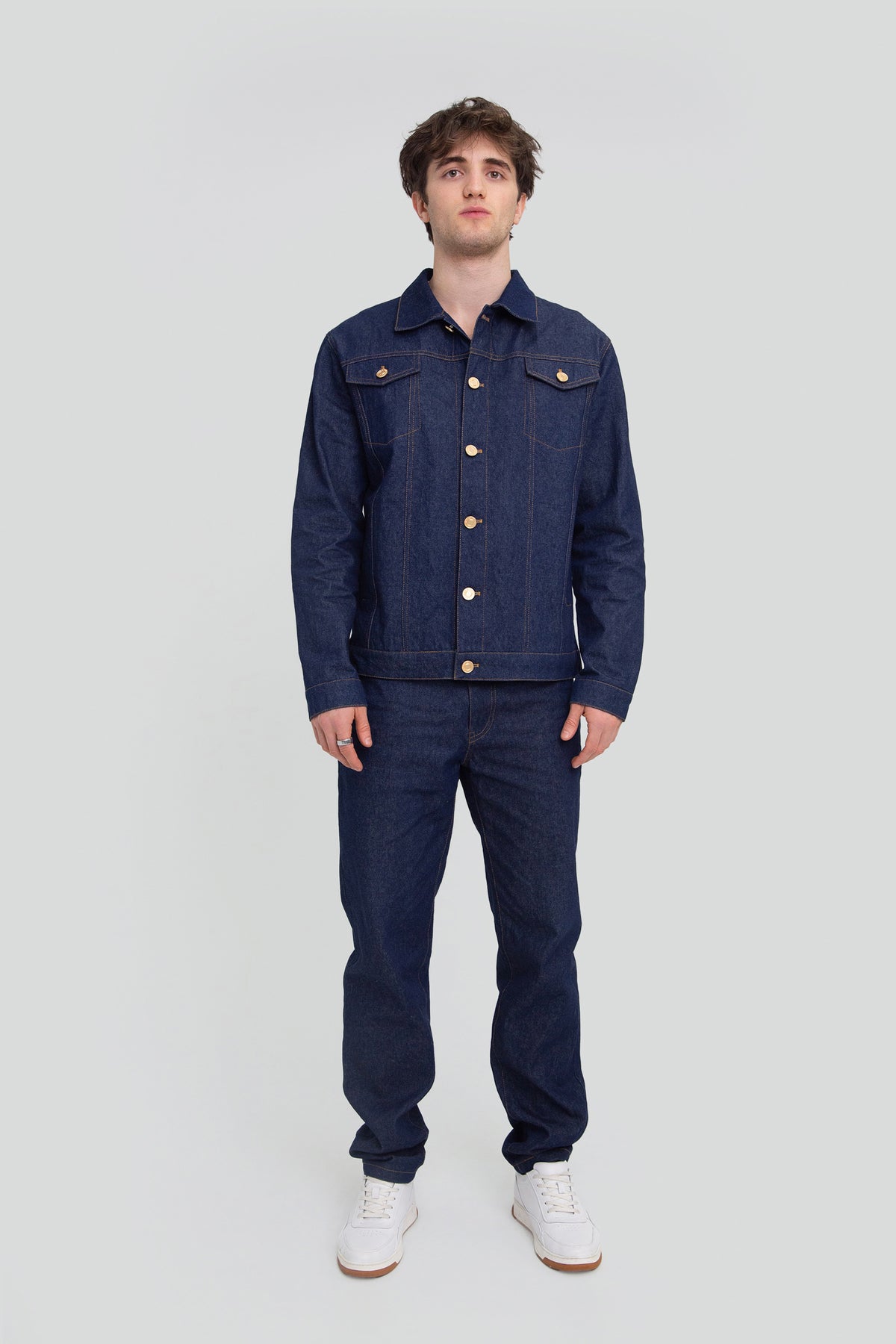 Man wearing a matching blue denim set featuring an oversized jacket and straight leg jeans with butterfly wing embroidery