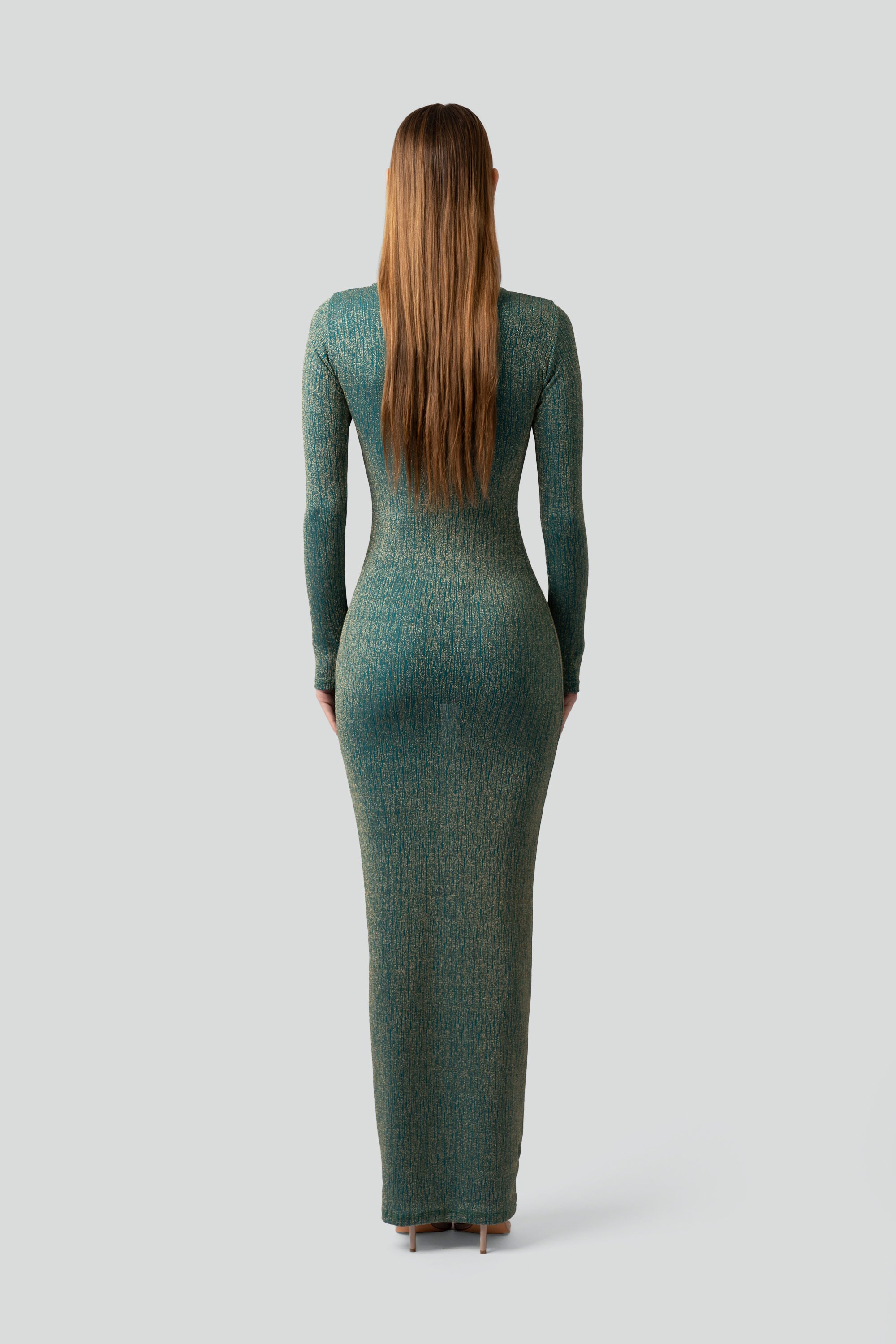 Back view of a woman wearing a teal long-sleeve dress on a gray background