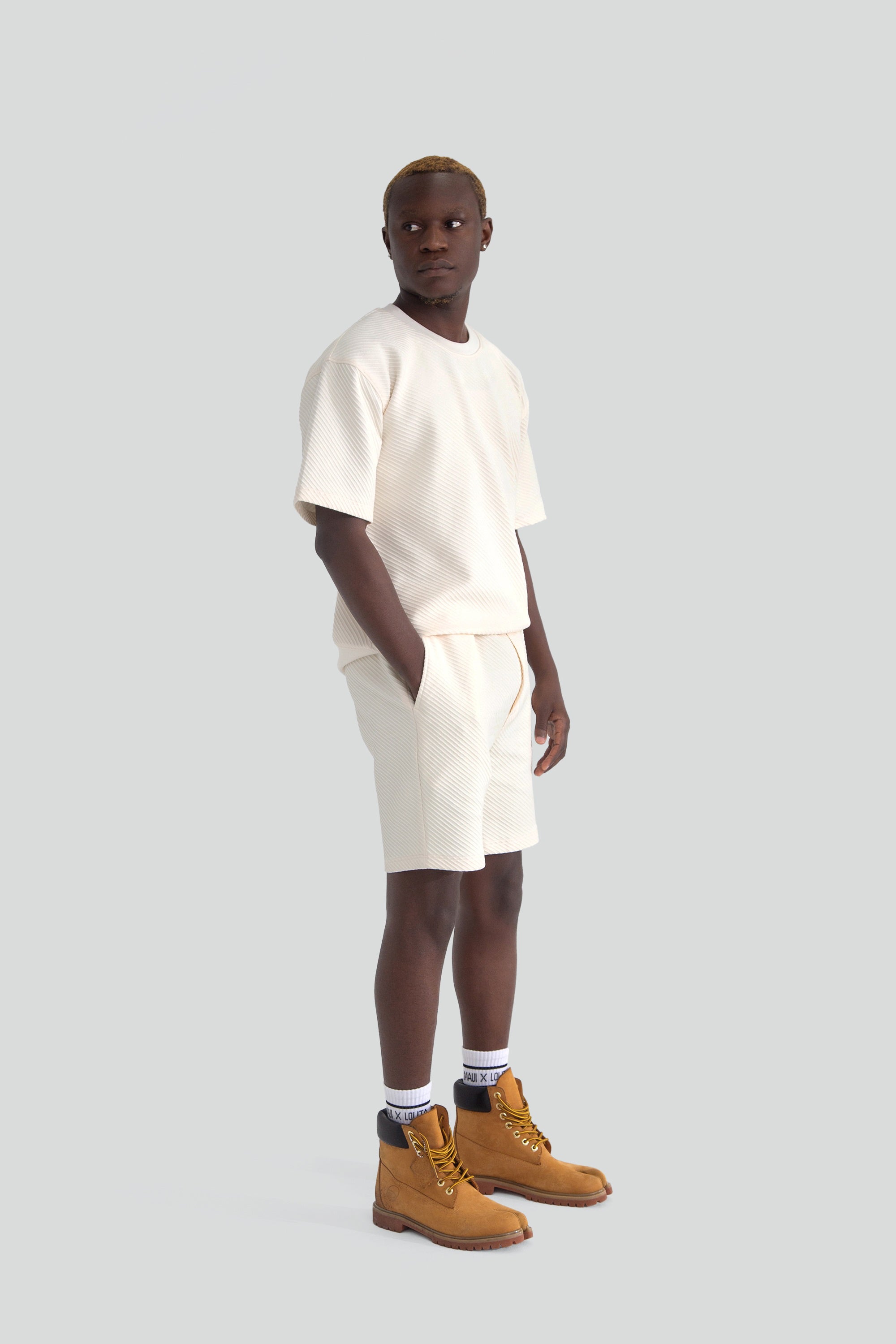 Person wearing a white top and shorts on a plain background