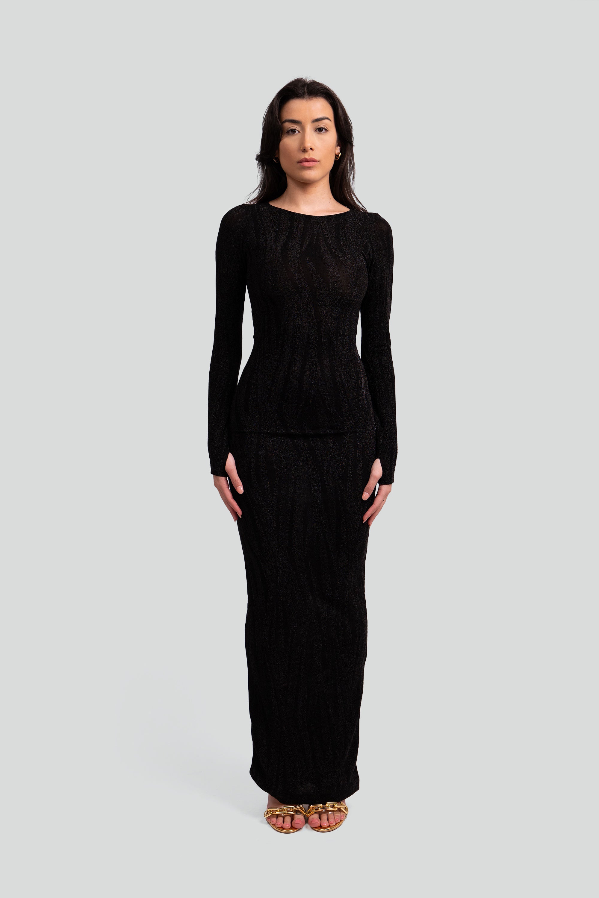 Woman wearing a black patterned dress on a gray background