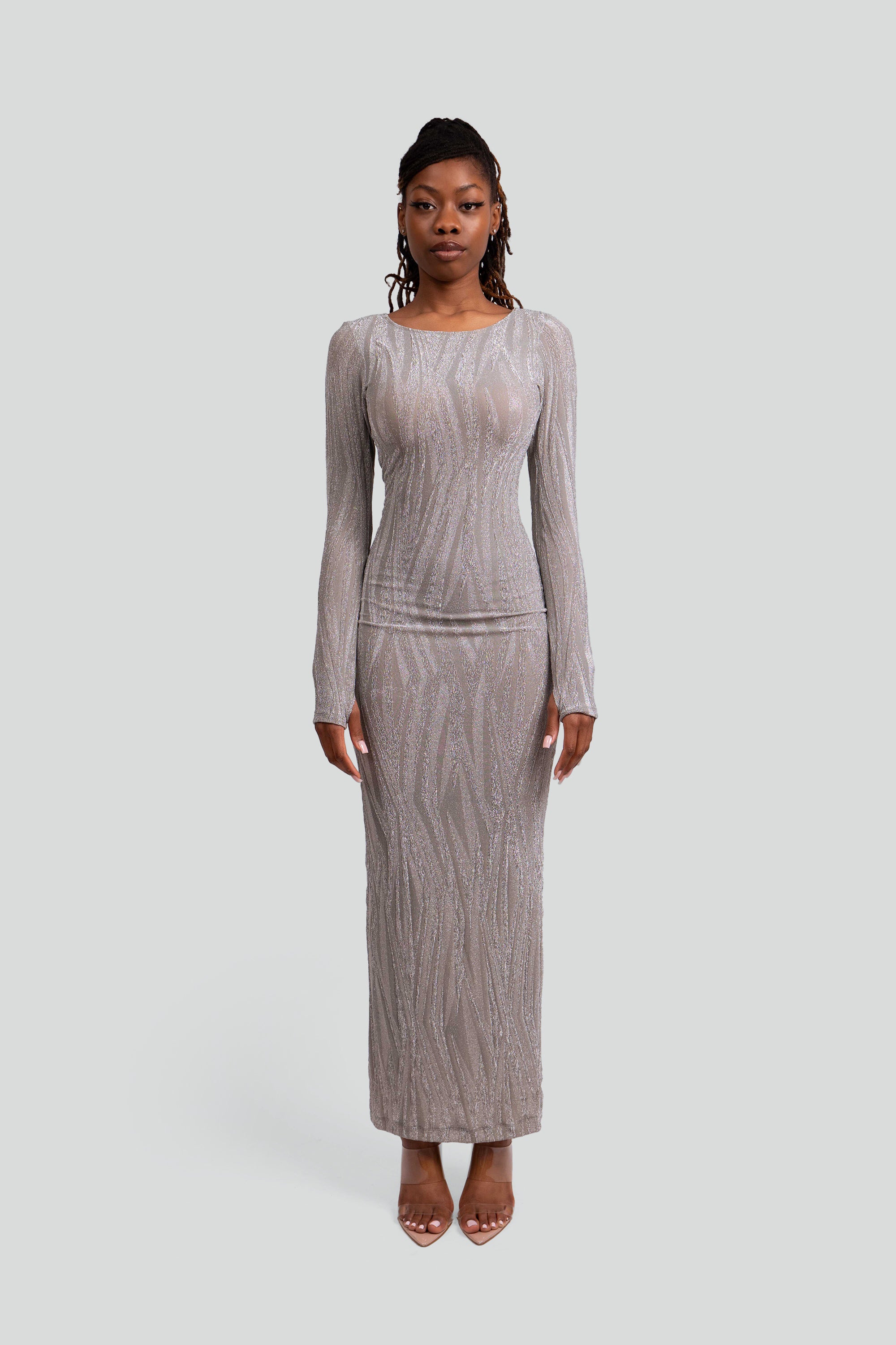 Woman wearing a silver patterned dress on a gray background