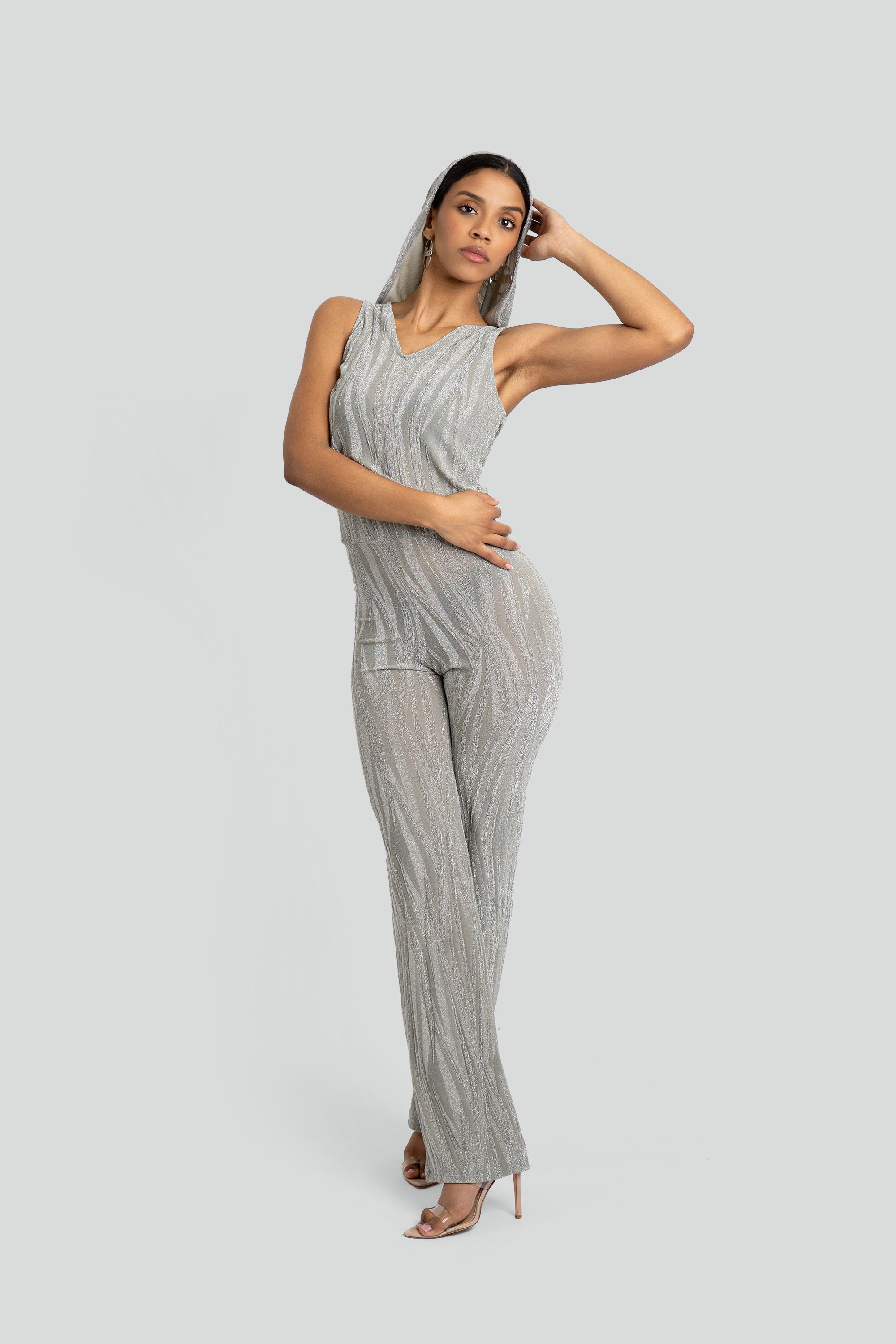 Woman wearing a silver hooded jumpsuit on a white background