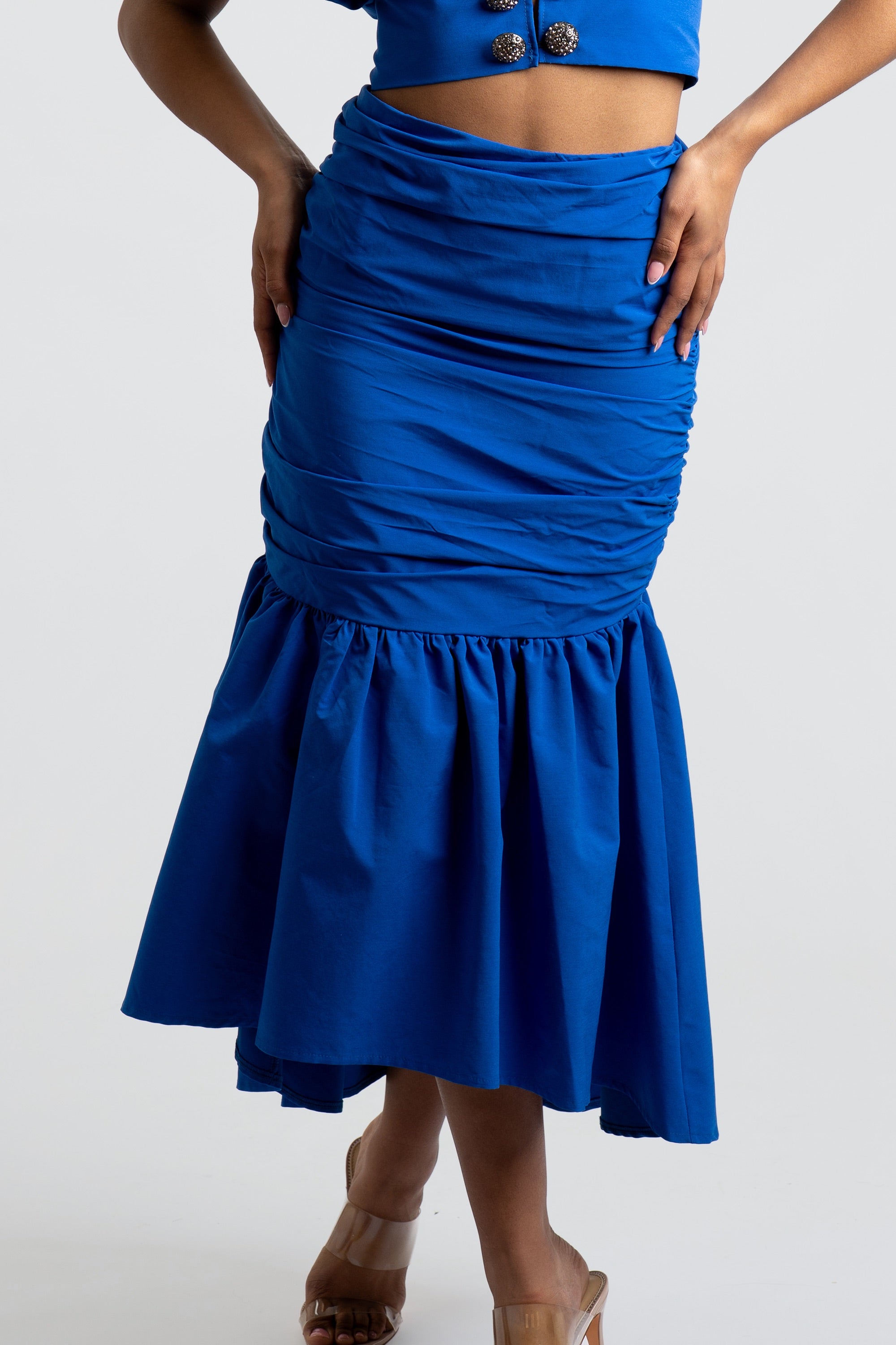 Close up of a blue ruched bubble skirt on a white background