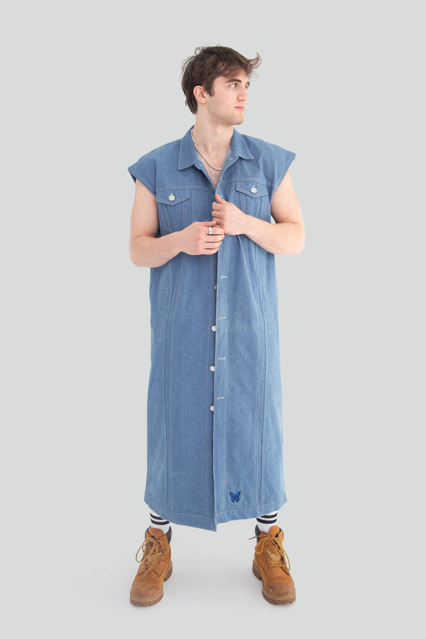 Man wearing a dark blue structured denim vest jacket styled fully buttoned up with a clean longline silhouette
