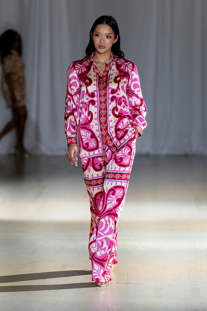 Model wearing a pink and white patterned outfit on a runway.