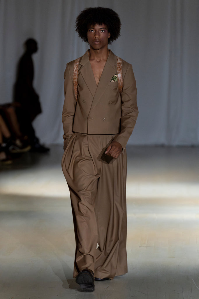 Model wearing a brown suit on the runway