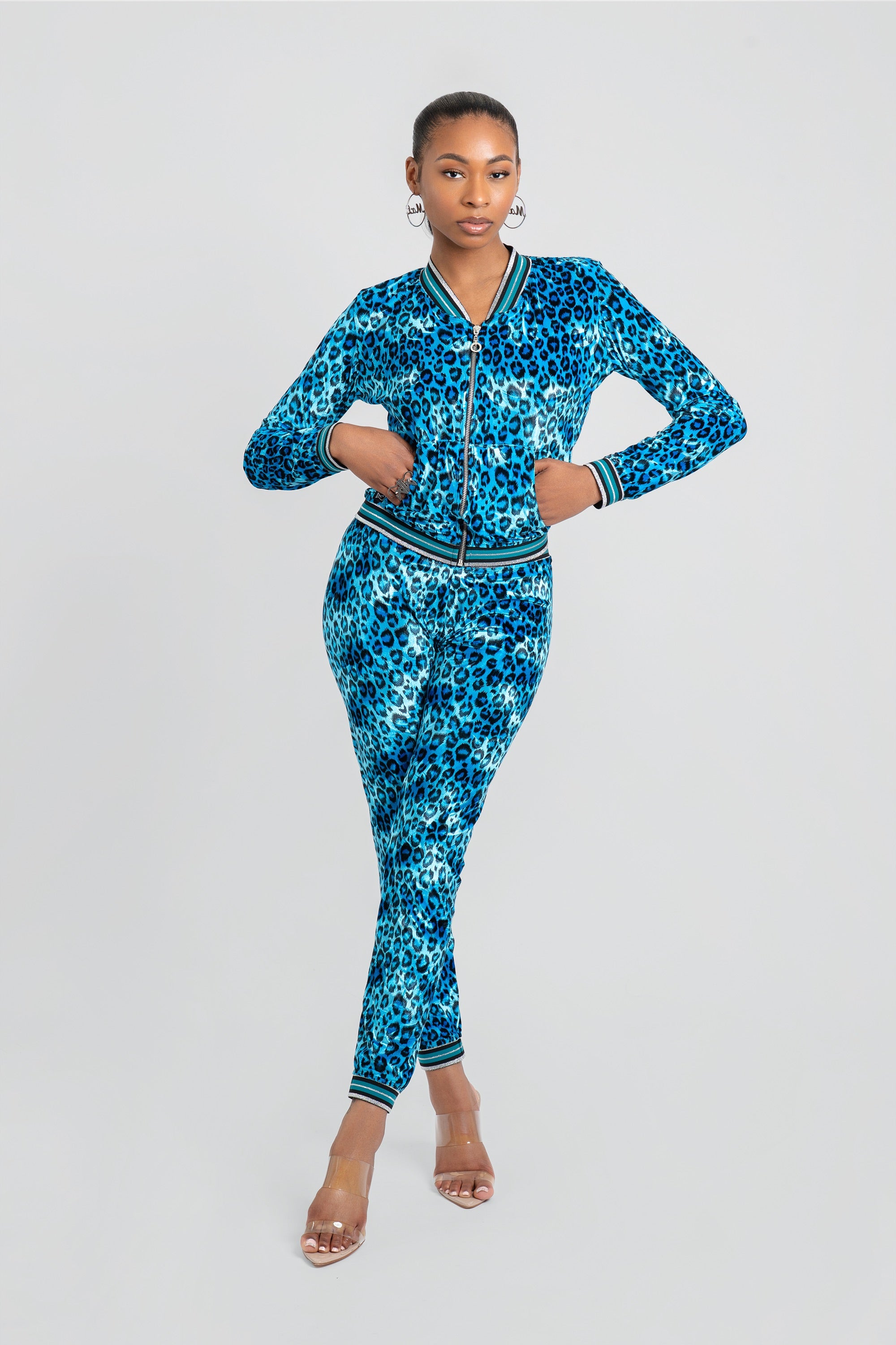Woman wearing a blue leopard print velour tracksuit on a white background
