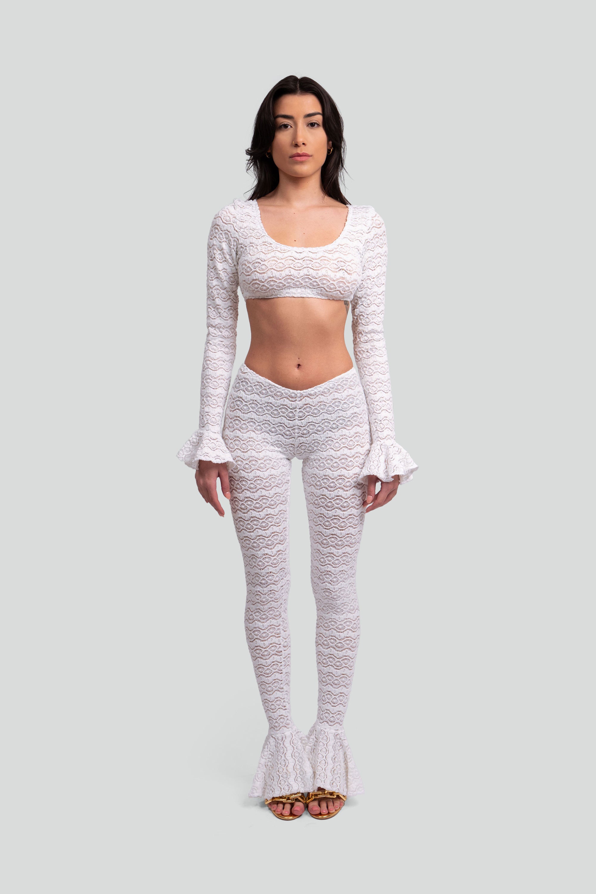 Woman wearing a white lace outfit on a gray background