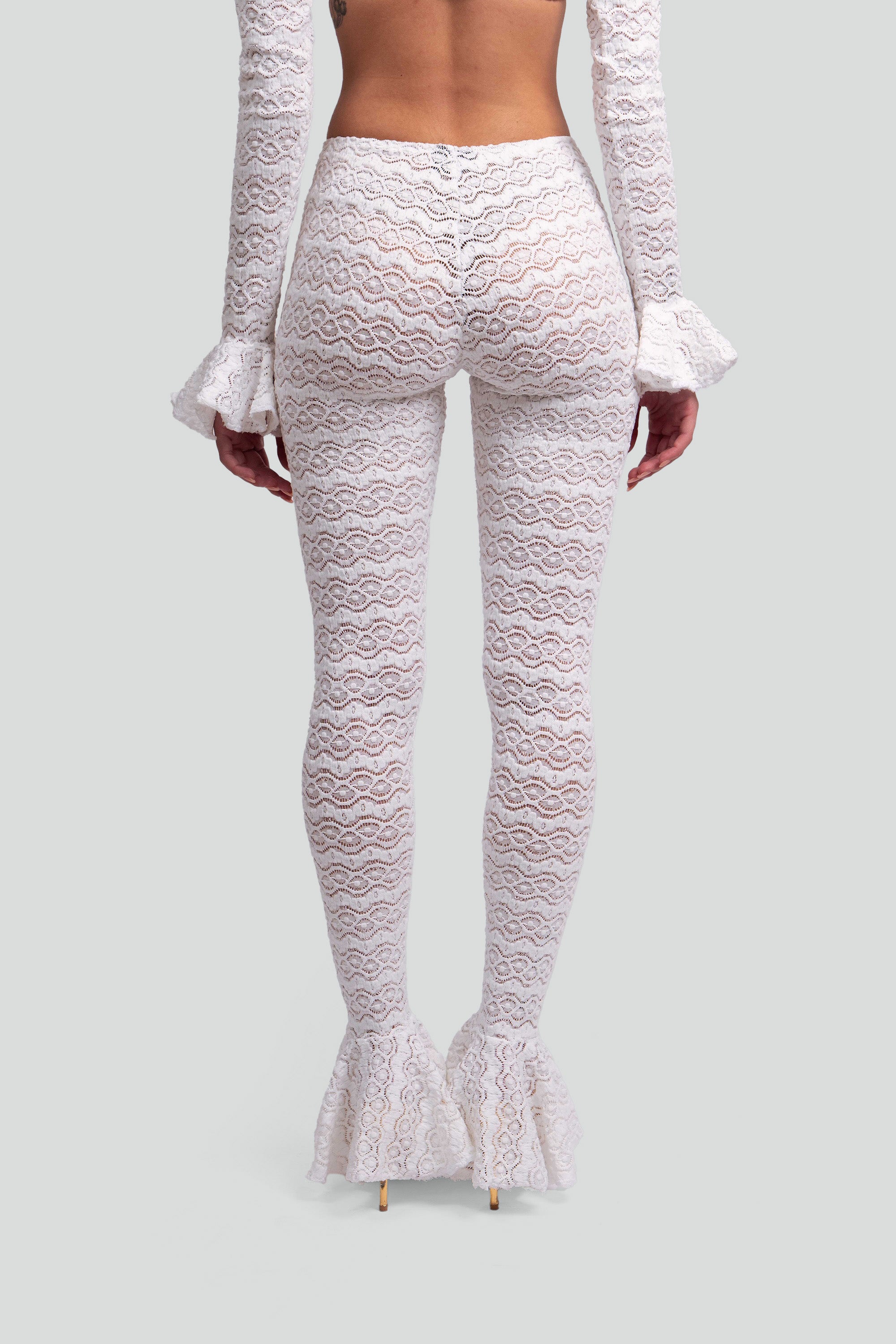 White lace pants with ruffled hem on a gray background