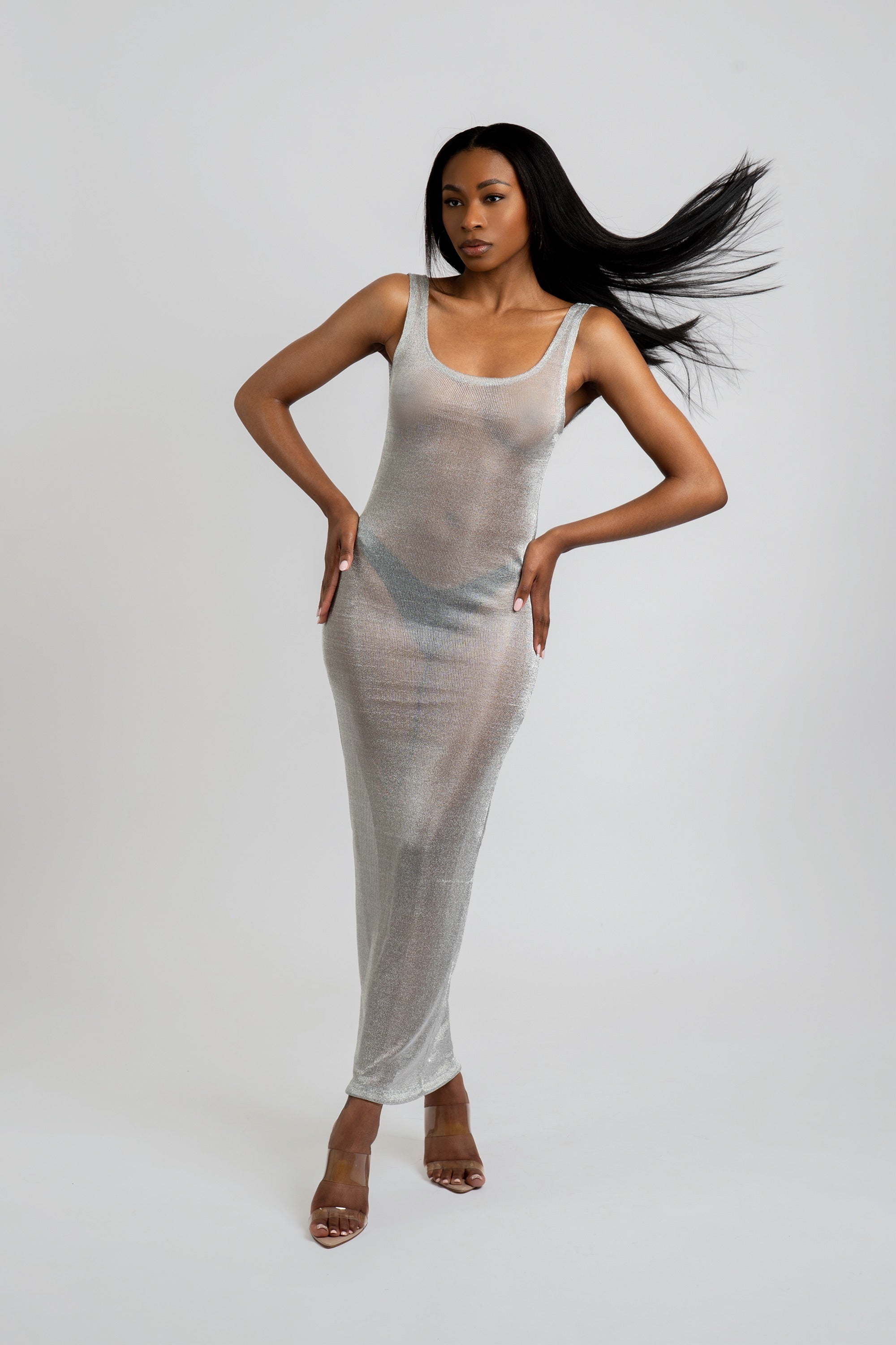 Woman wearing a silver metallic dress against a white background