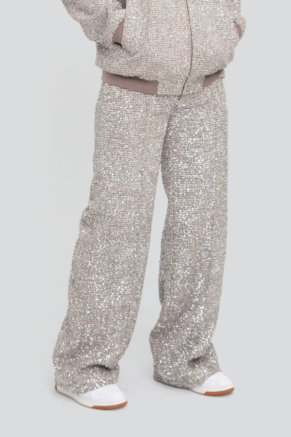 Close up view of highly reflective silver metallic tweed fabric highlighting woven lurex fibers and crushed foil shards